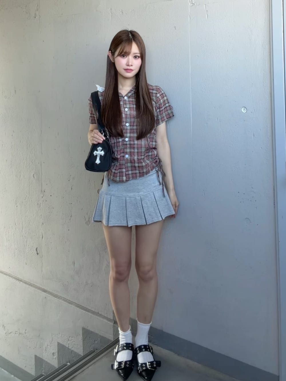 グレー系のスカート、ピンク系のシャツ/ブラウス、ブラック系のショルダーバッグを着用したレディースの夏コーディネートの2枚目の写真