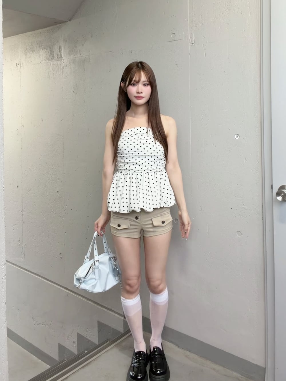 ホワイト系のチューブトップ、ベージュ系のスウェットパンツ、ブルー系のショルダーバッグを着用したレディースの夏コーディネートの2枚目の写真