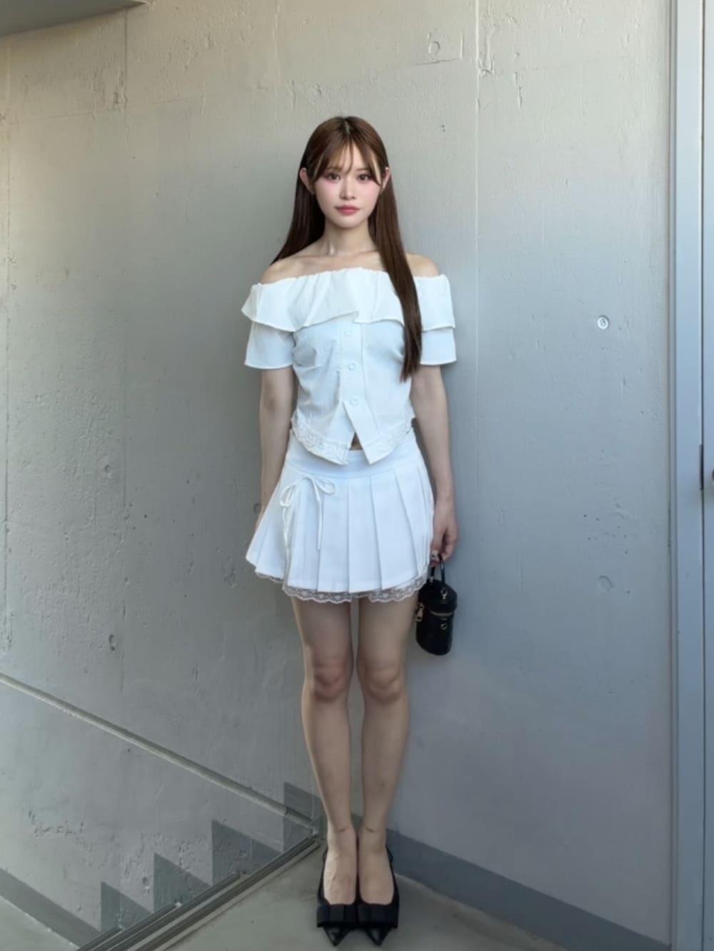 ホワイト系のスカート、ホワイト系のTシャツ/カットソー、ブラック系のパンプスを着用したレディースの夏コーディネートの2枚目の写真