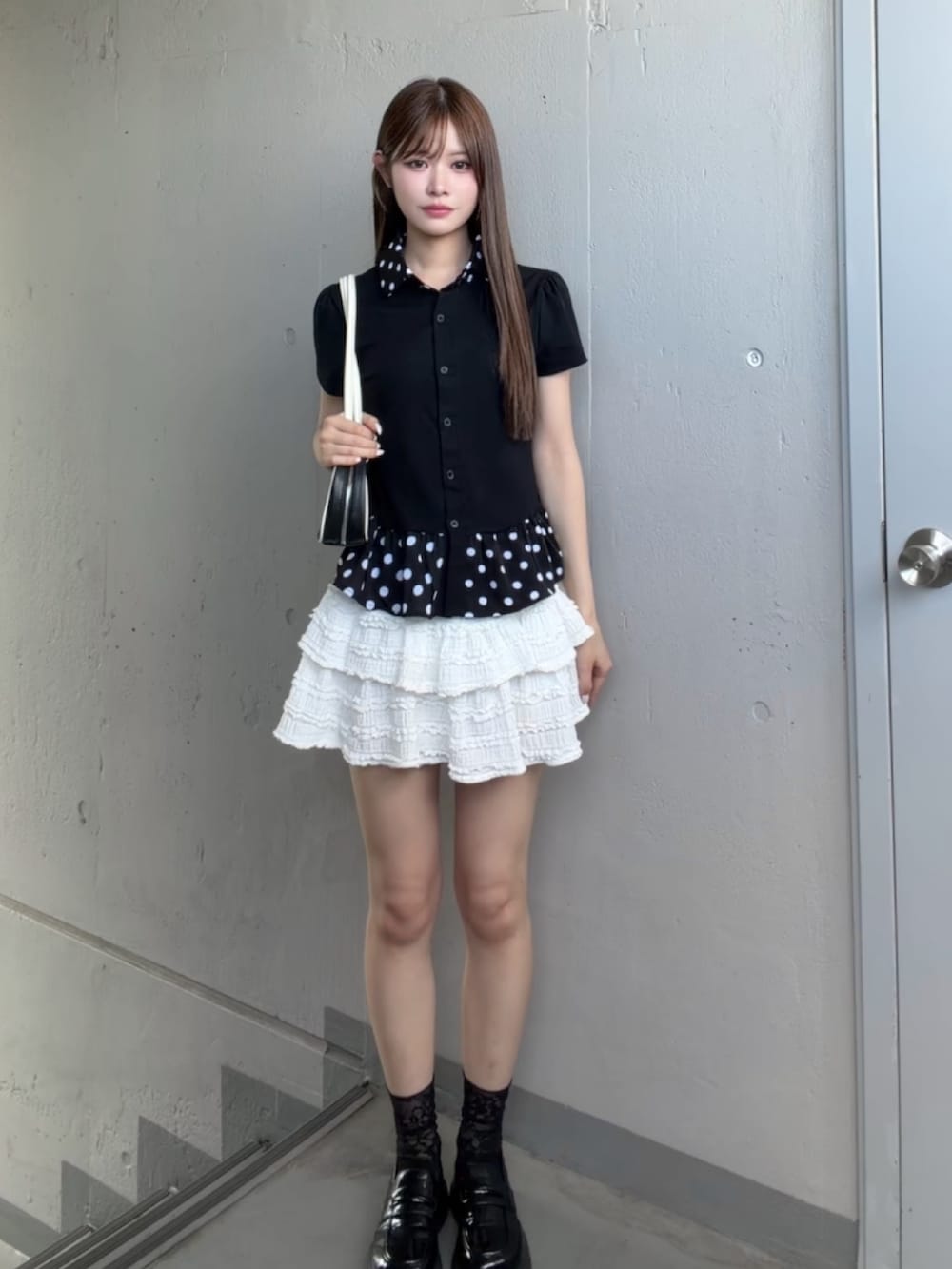 ホワイト系のスカート、ブラック系のシャツ/ブラウスを着用したレディースの夏コーディネートの2枚目の写真