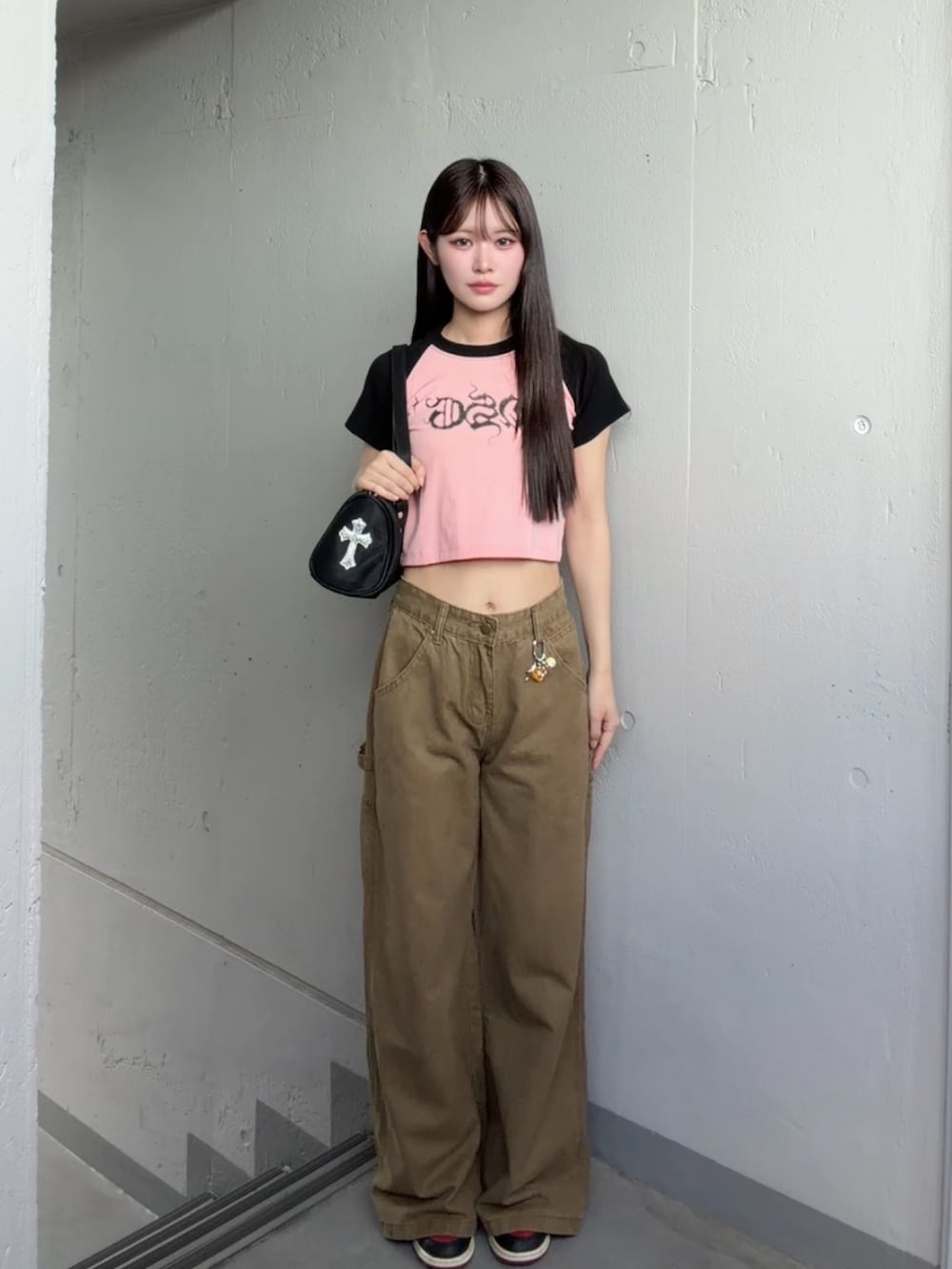 ベージュ系のカーゴパンツ、ピンク系のTシャツ/カットソーを着用したレディースの秋コーディネートの2枚目の写真