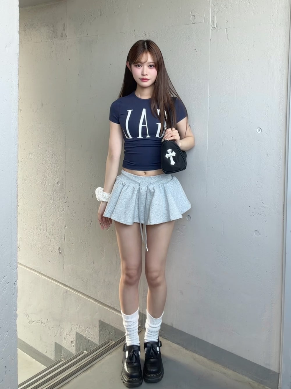 ブラック系のショルダーバッグ、グレー系のスカート、ブルー系のTシャツ/カットソーを着用したレディースの夏コーディネートの2枚目の写真