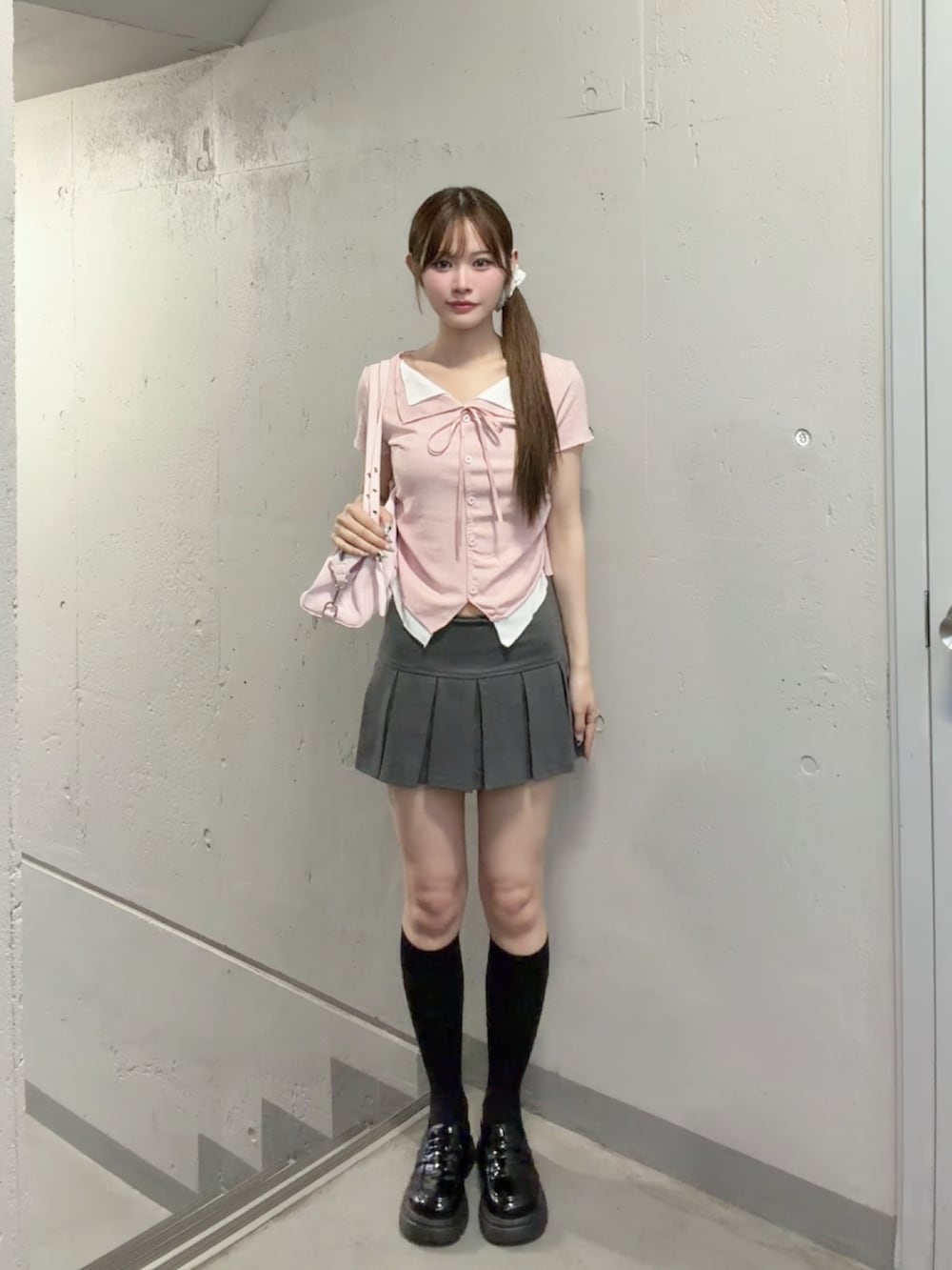 グレー系のスカート、ピンク系のシャツ/ブラウス、ピンク系のショルダーバッグを着用したレディースの夏コーディネートの2枚目の写真