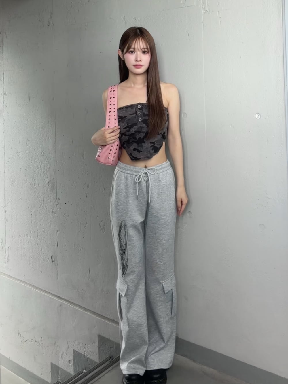 グレー系のスウェットパンツ、ブラック系のチューブトップ、ピンク系のショルダーバッグを着用したレディースの夏コーディネートの2枚目の写真