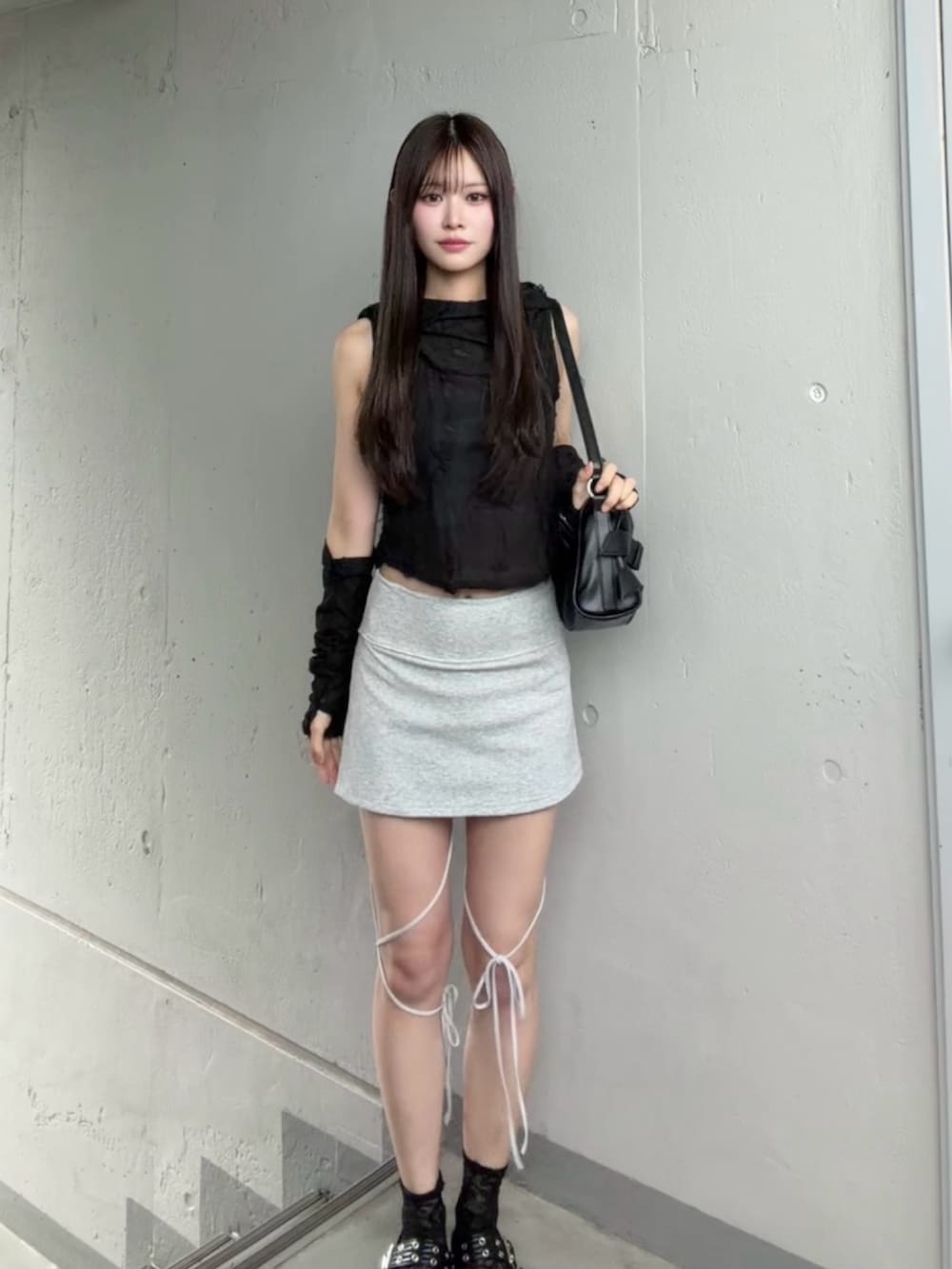 グレー系のスカート、ブラック系のTシャツ/カットソーを着用したレディースの秋コーディネートの2枚目の写真