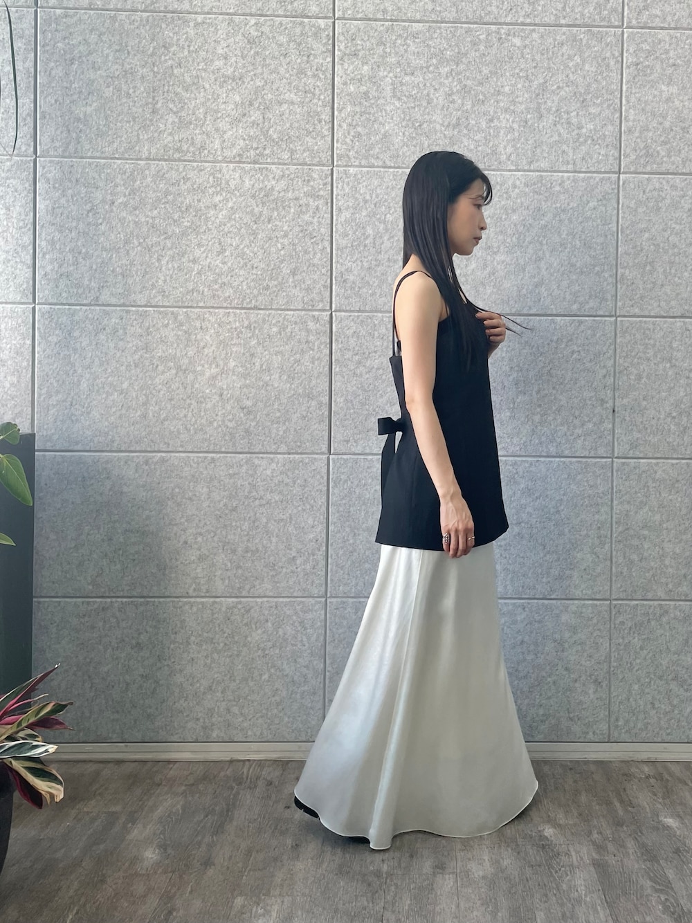 ブラック系のキャミソール、ホワイト系のスカートを着用したレディースの夏コーディネートの4枚目の写真