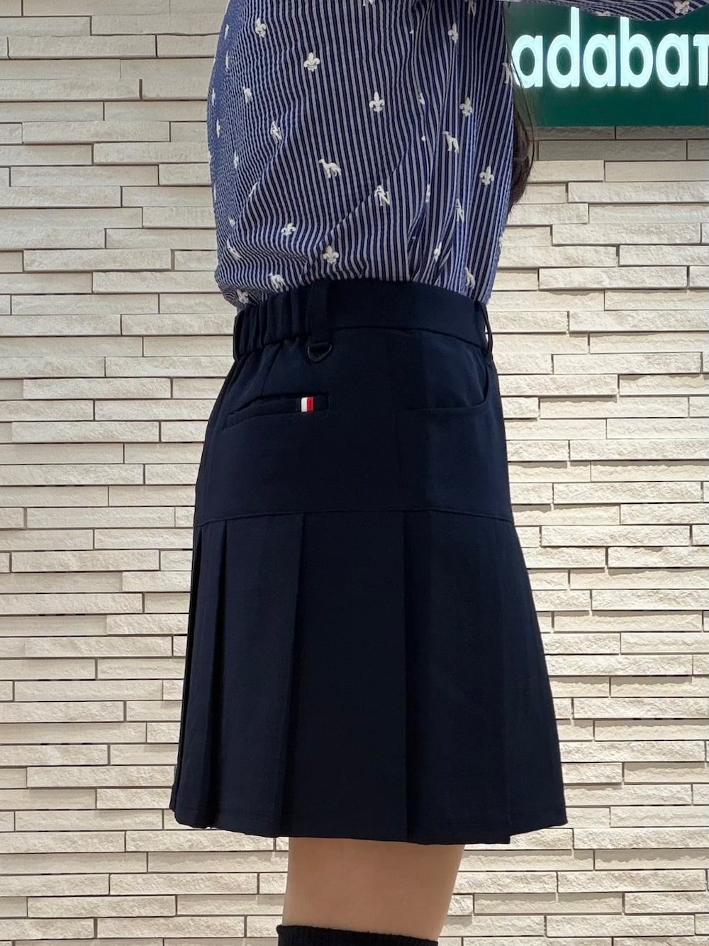 ホワイト系のベスト、ホワイト系のTシャツ/カットソー、ブルー系のスカートを着用したレディースの秋コーディネートの8枚目の写真