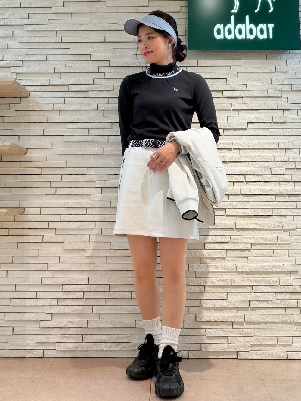 ホワイト系のブルゾン、ブラック系のTシャツ/カットソー、ホワイト系のスカートを着用したレディースの秋コーディネートの9枚目の写真