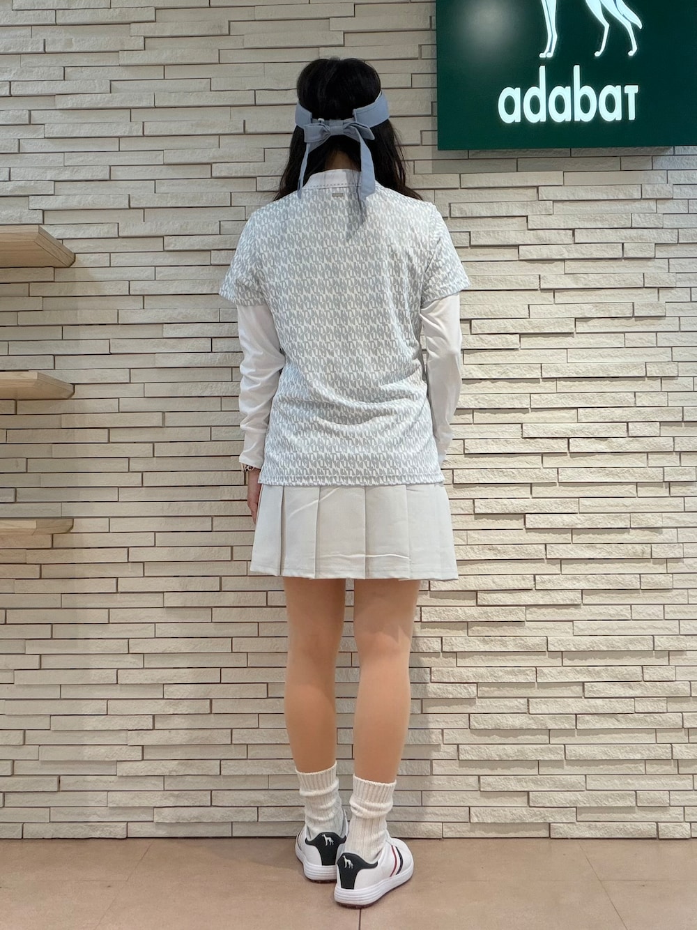 ホワイト系のTシャツ/カットソー、グレー系のポロシャツ、グレー系のスカートを着用したレディースの秋コーディネートの7枚目の写真