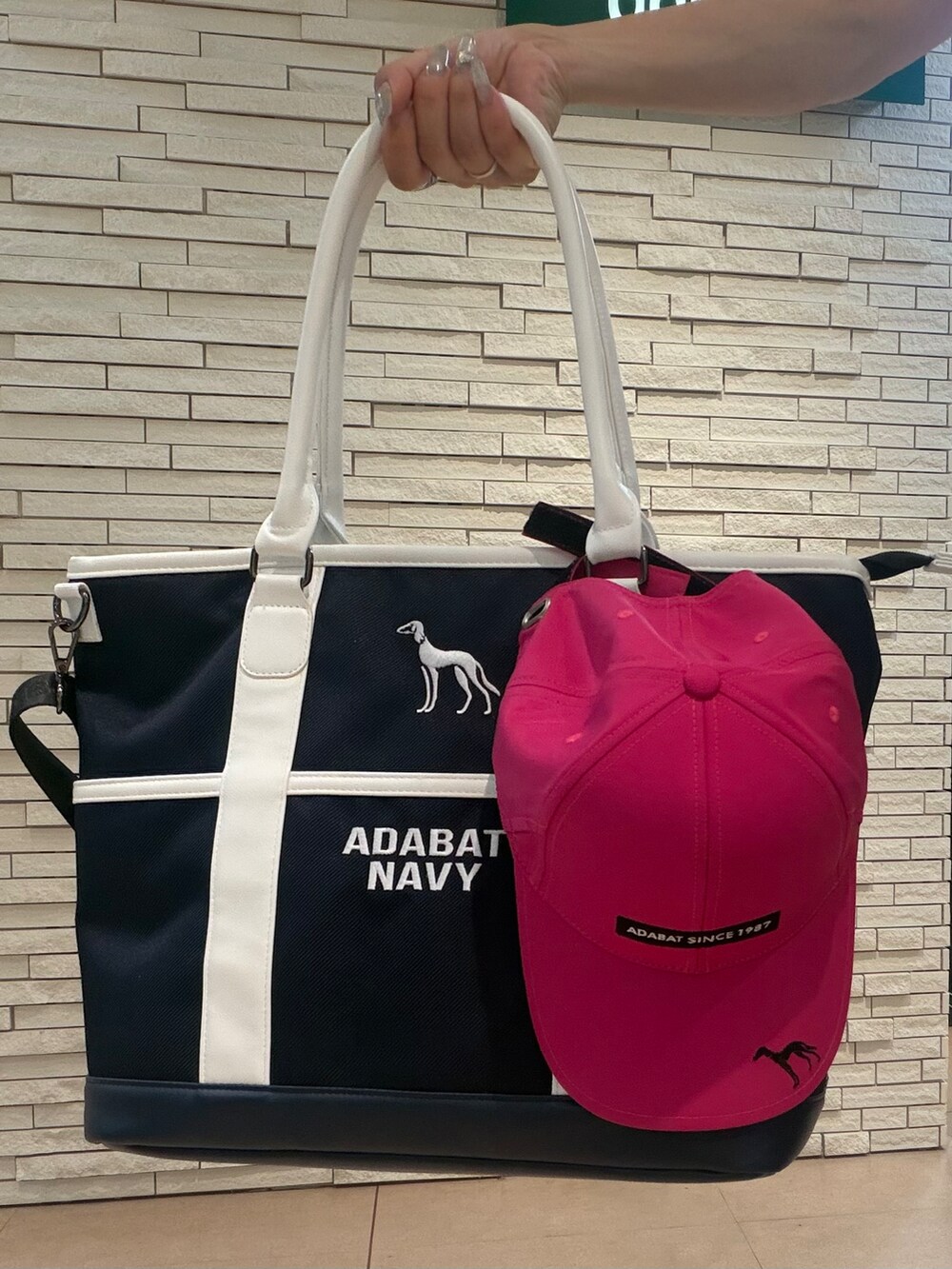 グレー系のポロシャツ、ブルー系のスカート、ブルー系のトートバッグを着用したレディースの夏コーディネートの9枚目の写真