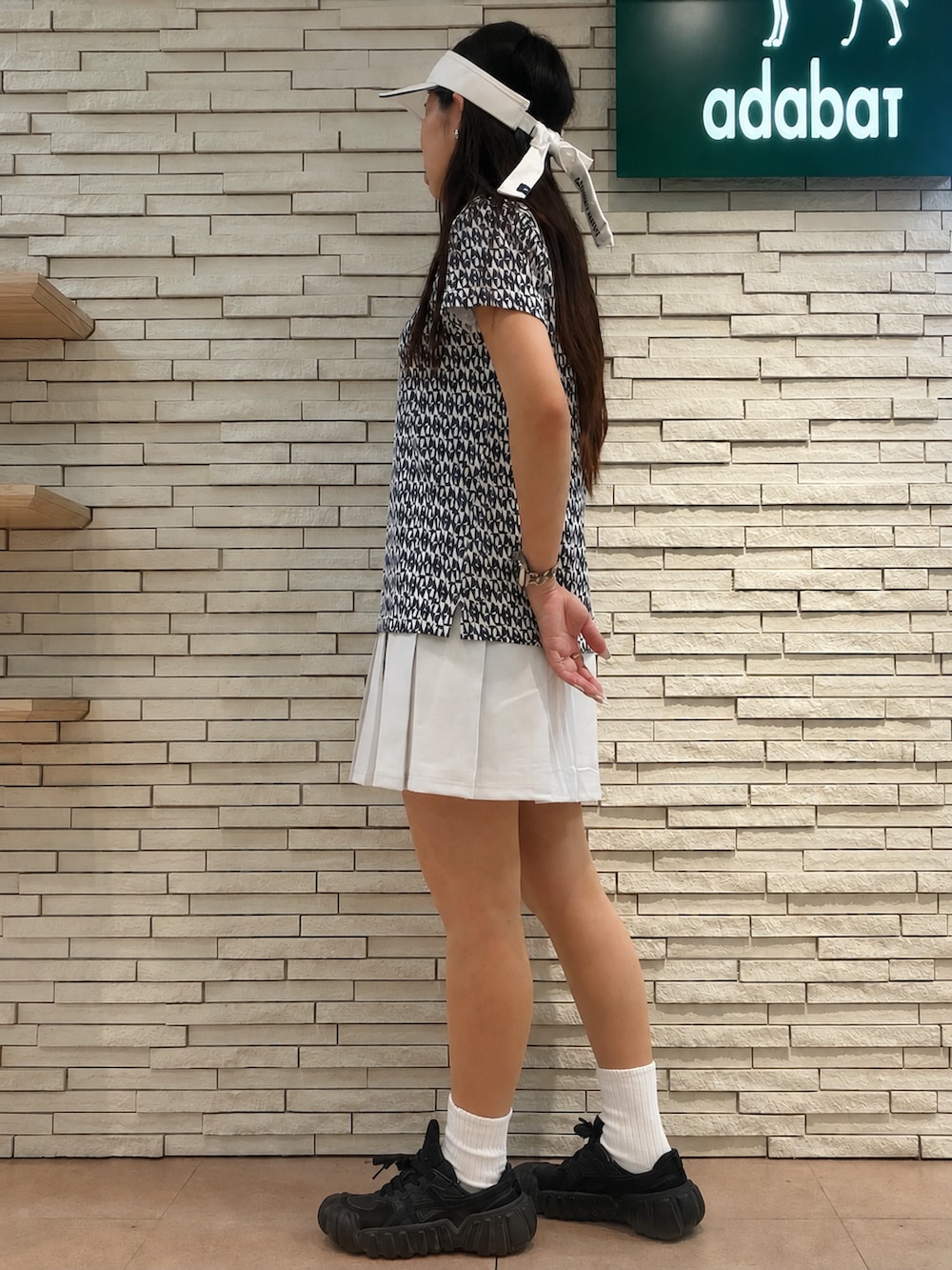 ブルー系のポロシャツ、ブルー系のカーディガン/ボレロ、グレー系のスカートを着用したレディースの夏コーディネートの6枚目の写真