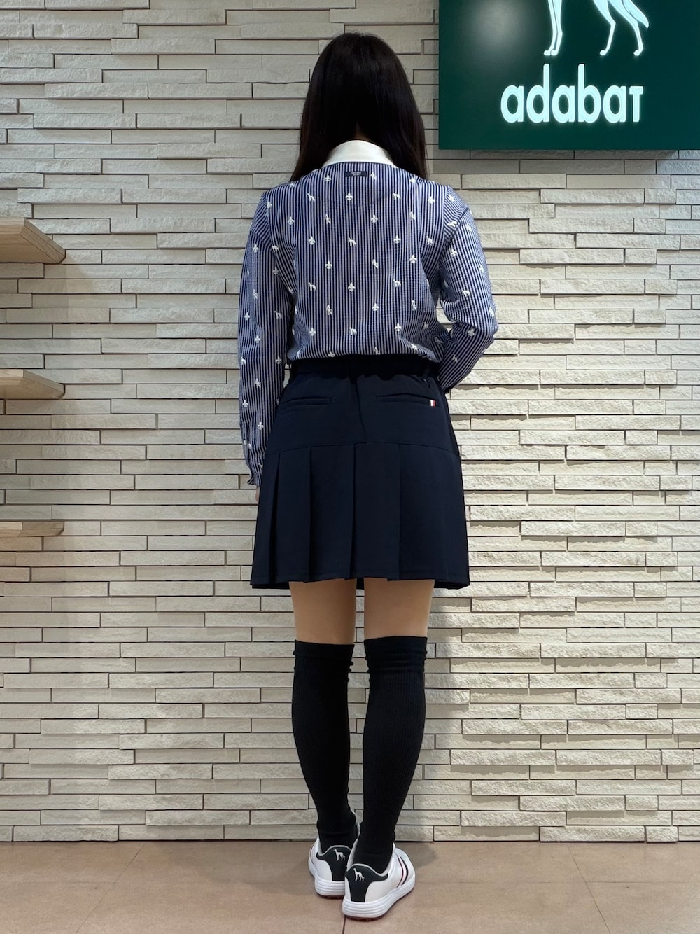 ホワイト系のベスト、ホワイト系のTシャツ/カットソー、ブルー系のスカートを着用したレディースの秋コーディネートの7枚目の写真