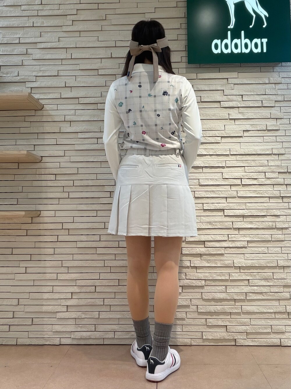 ベージュ系のTシャツ/カットソー、グレー系のスカート、ブルー系のトートバッグを着用したレディースの夏コーディネートの3枚目の写真