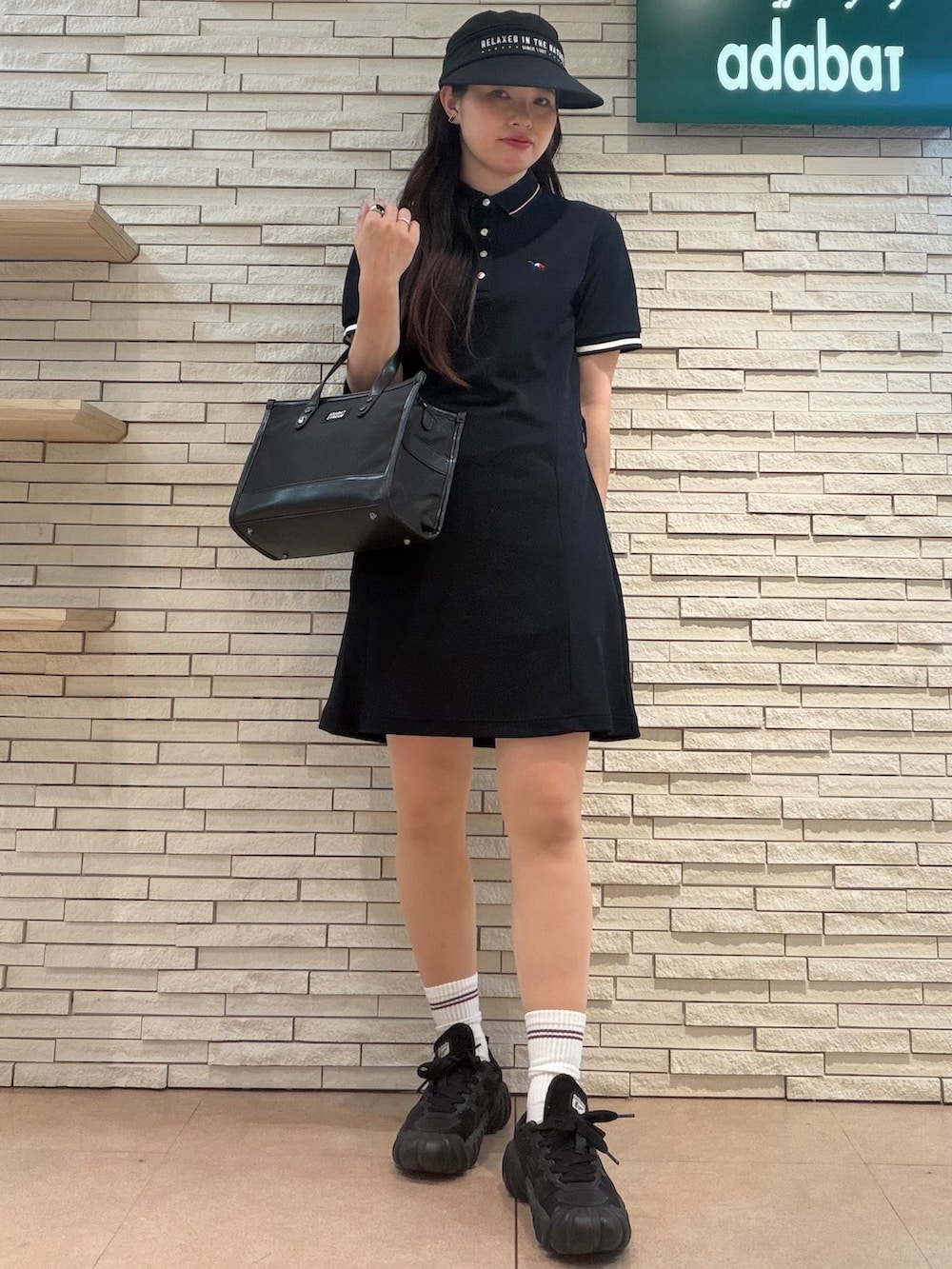 ブルー系のワンピース、ブラック系のトートバッグ、ブラック系のハットを着用したレディースの夏コーディネートの4枚目の写真