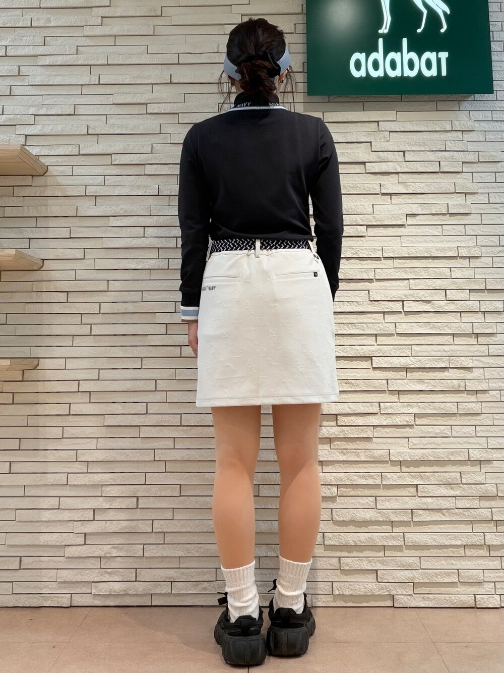 ブラック系のTシャツ/カットソー、ホワイト系のスカート、ブラック系のトートバッグを着用したレディースの秋コーディネートの3枚目の写真