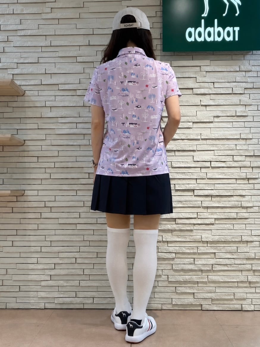 パープル系のポロシャツ、ブルー系のスカート、ホワイト系のトートバッグを着用したレディースの夏コーディネートの6枚目の写真