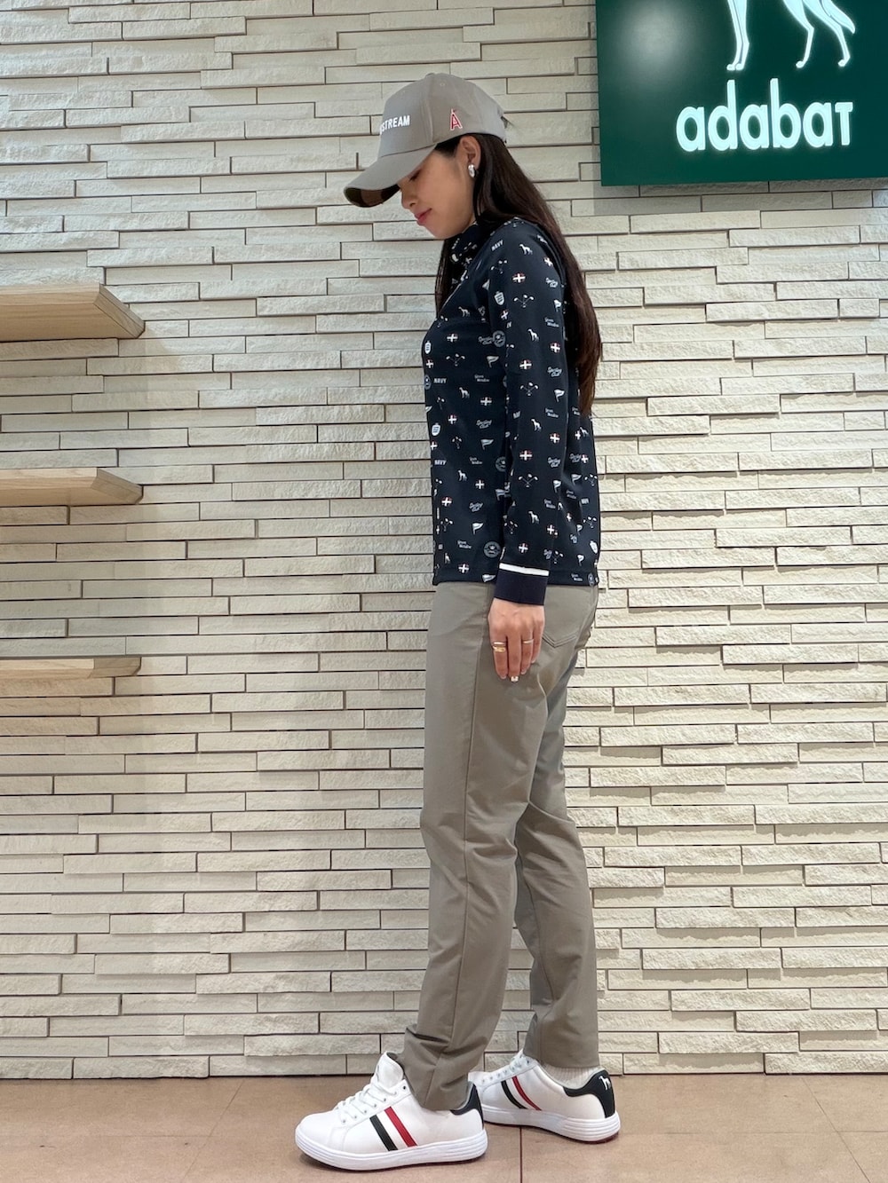 ブルー系のポロシャツ、ベージュ系のその他パンツ、ブルー系のトートバッグを着用したレディースの夏コーディネートの2枚目の写真