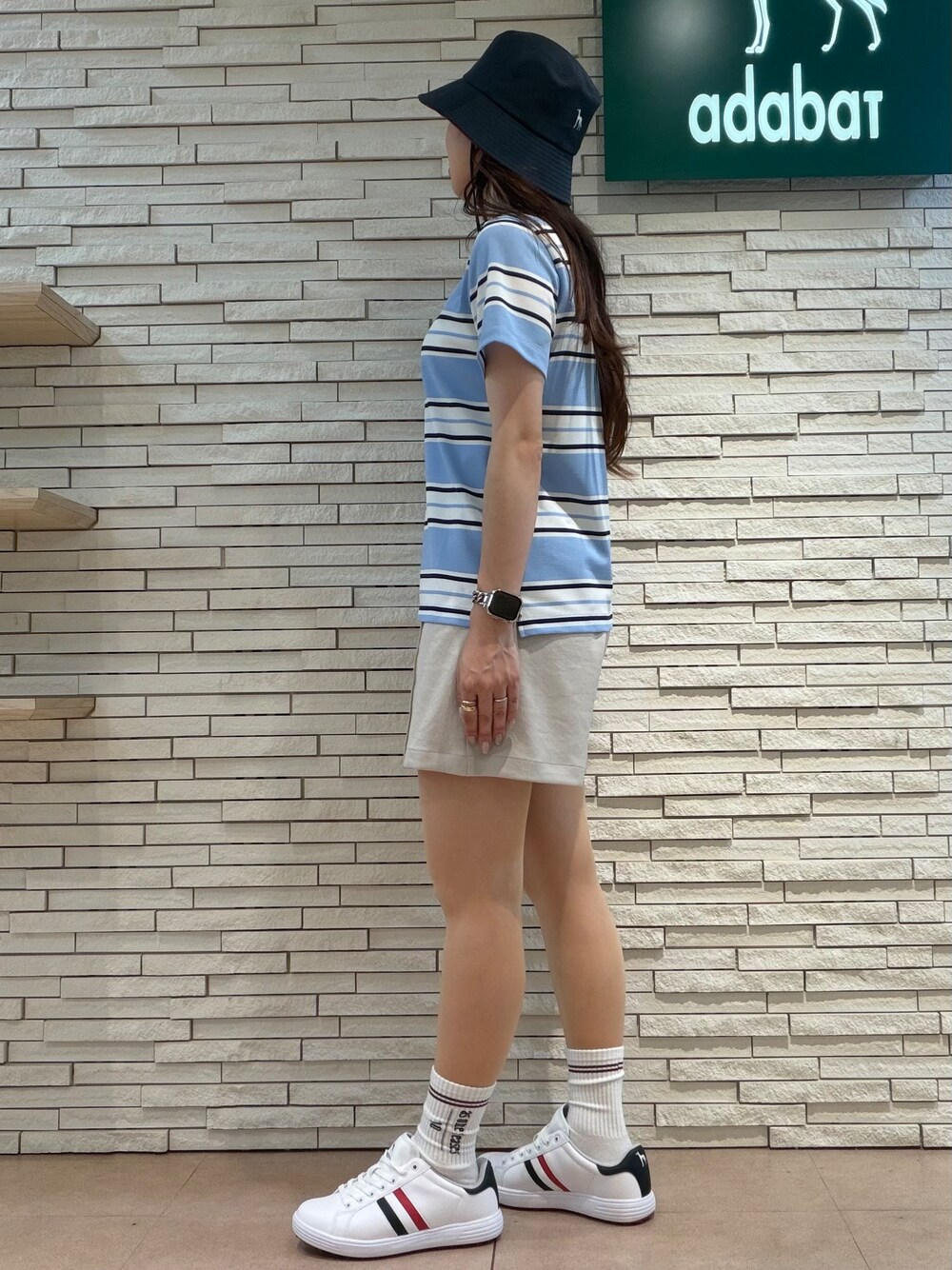 ブルー系のポロシャツ、ベージュ系のその他パンツ、ブルー系のトートバッグを着用したレディースの夏コーディネートの2枚目の写真