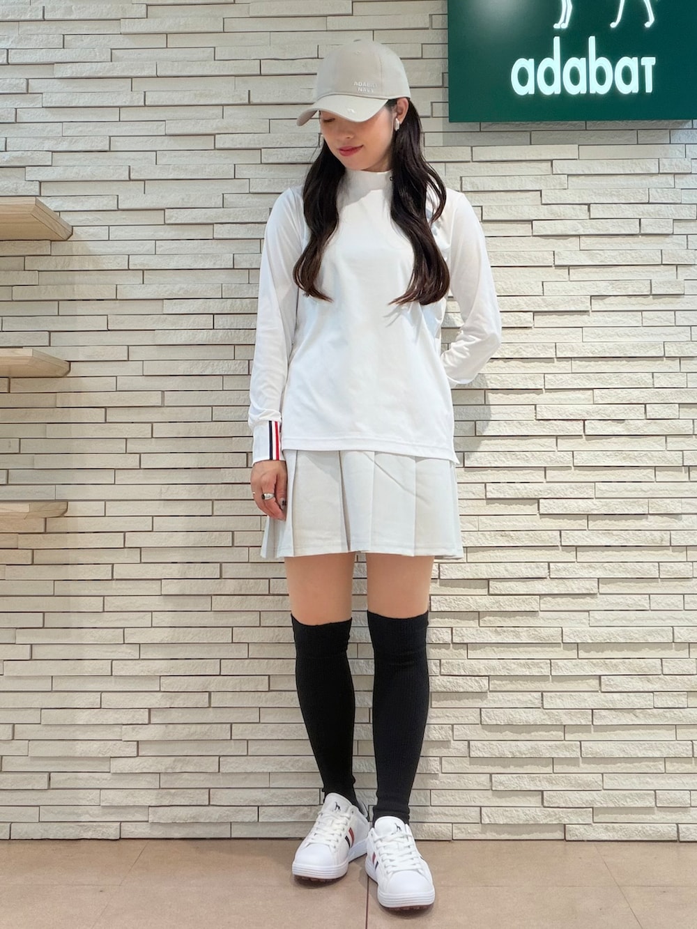 ホワイト系のTシャツ/カットソー、グレー系のスカート、ベージュ系のトートバッグを着用したレディースの秋コーディネートの6枚目の写真