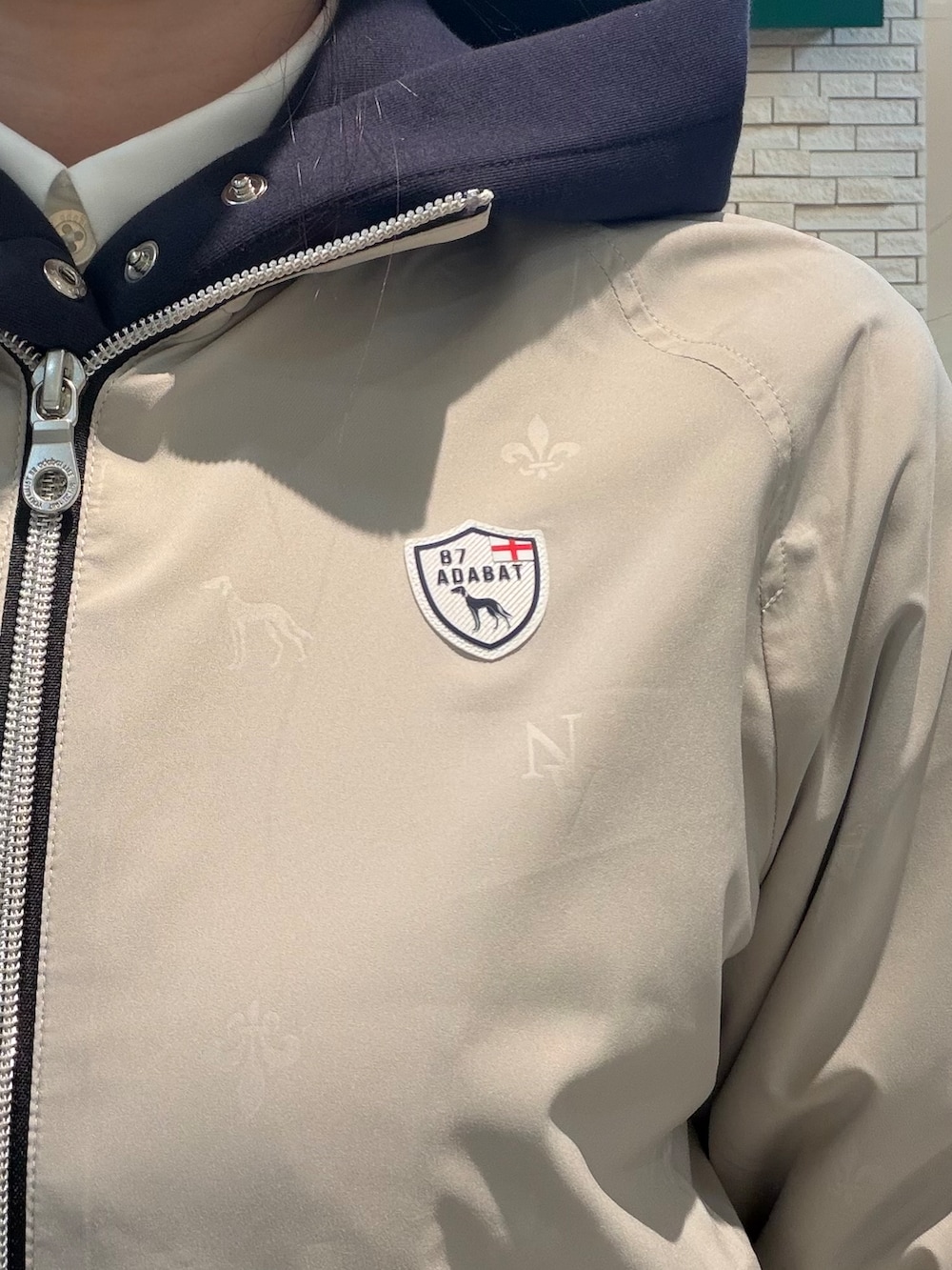 ホワイト系のTシャツ/カットソー、ブルー系のワンピース、ベージュ系のブルゾンを着用したレディースの秋コーディネートの7枚目の写真