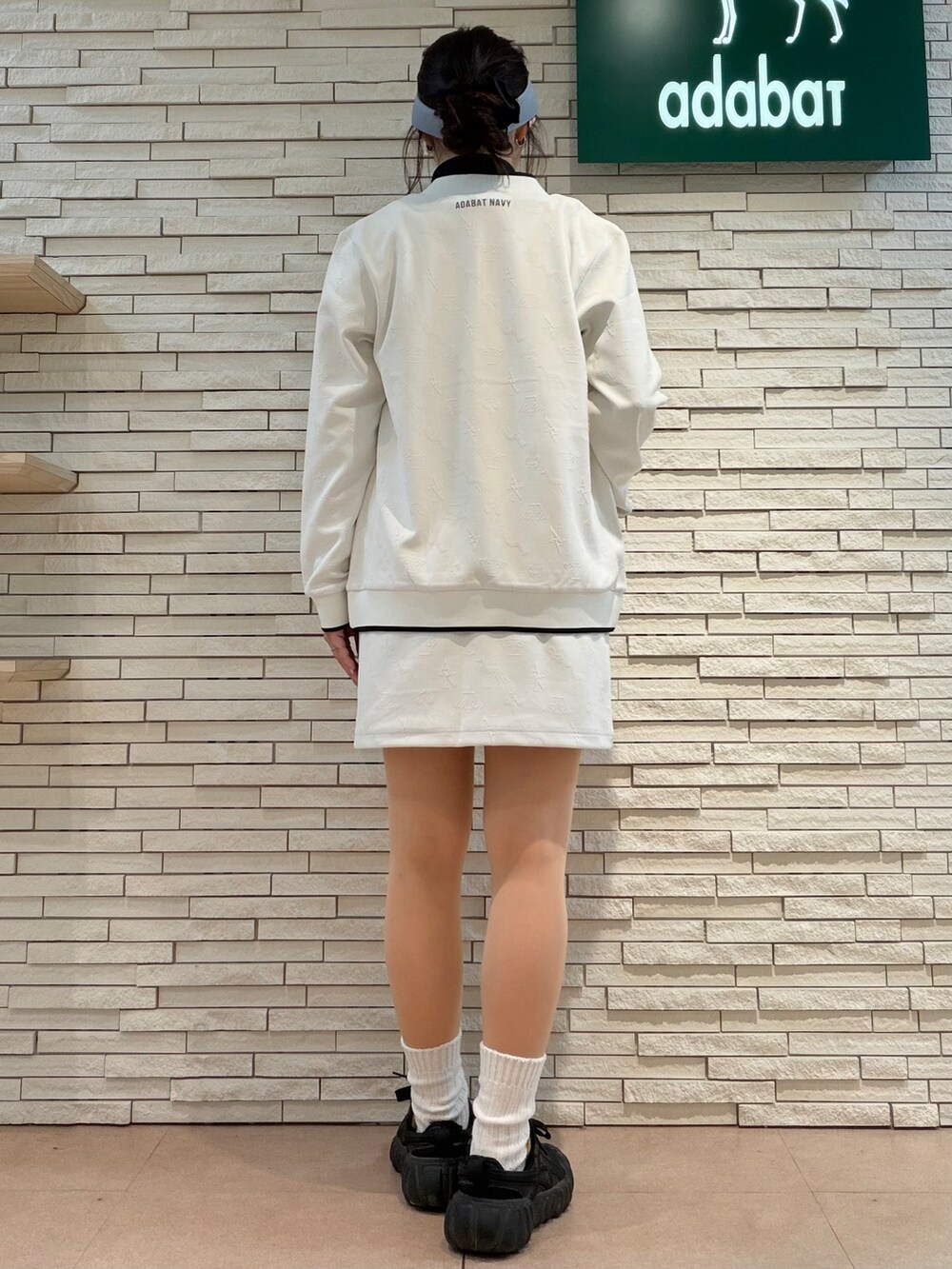 ホワイト系のブルゾン、ブラック系のTシャツ/カットソー、ホワイト系のスカートを着用したレディースの秋コーディネートの3枚目の写真