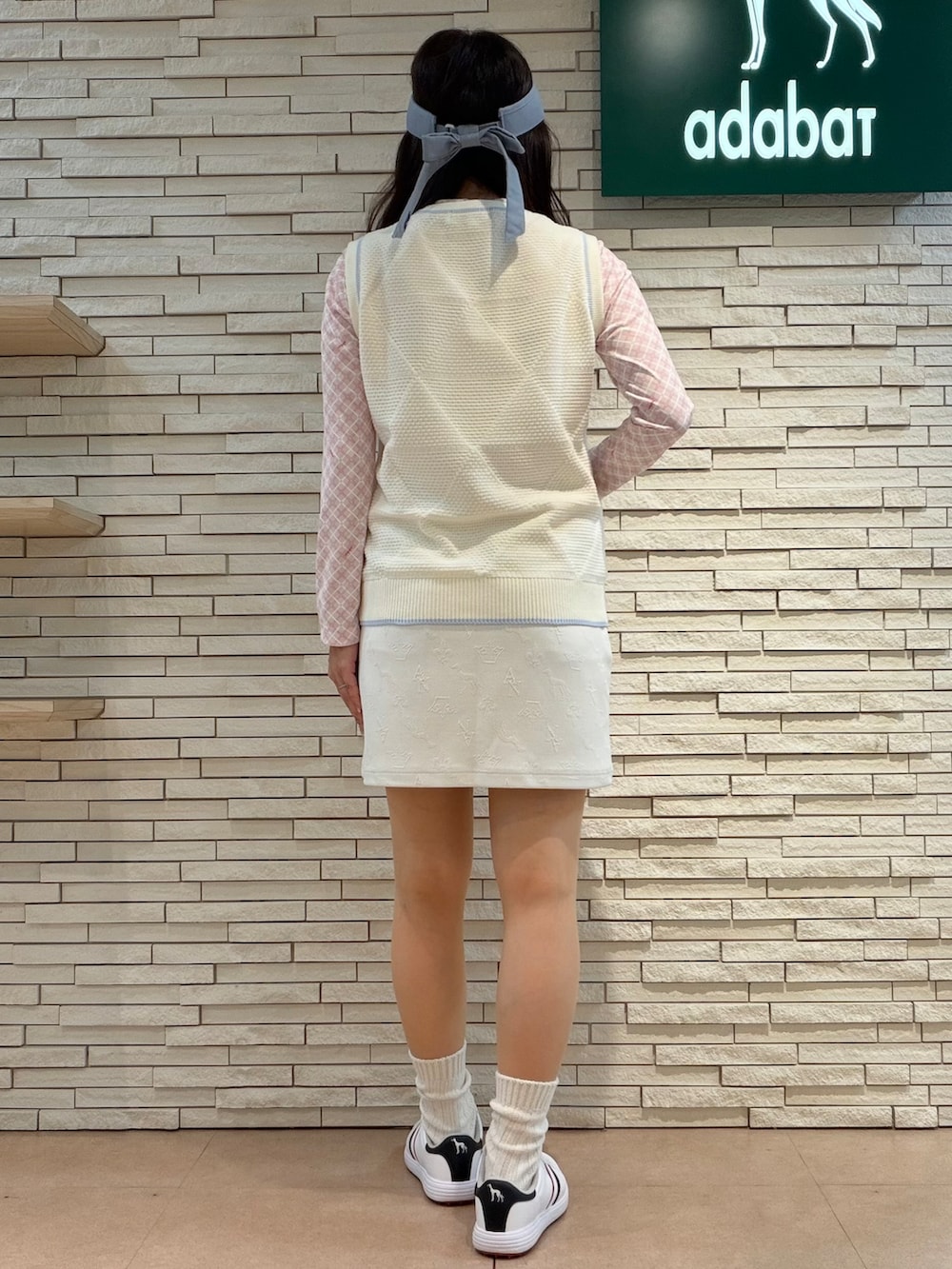ピンク系のTシャツ/カットソー、ホワイト系のベスト、ホワイト系のスカートを着用したレディースの秋コーディネートの3枚目の写真