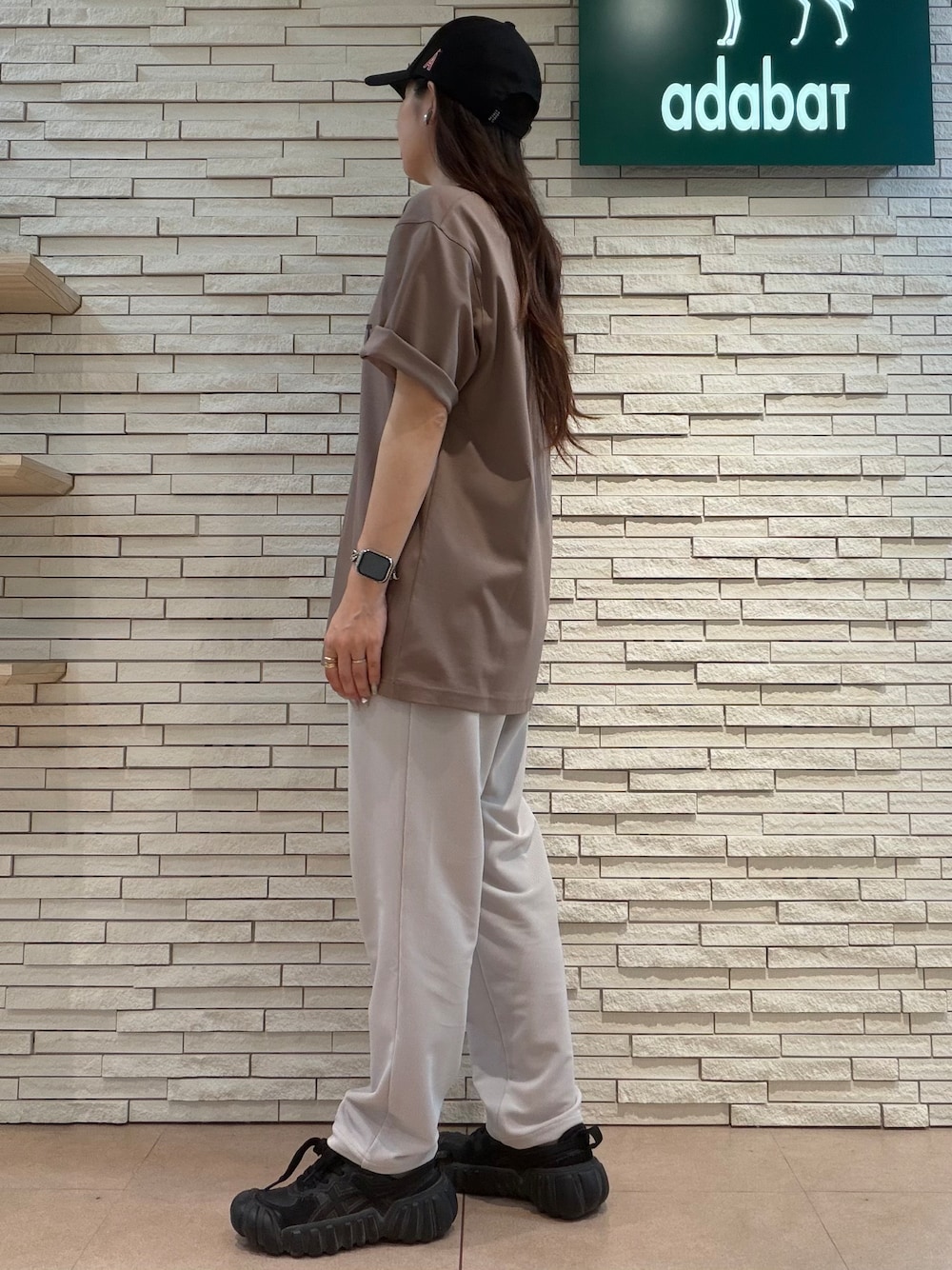 ブラウン系のTシャツ/カットソー、ベージュ系のその他パンツ、ブラック系のキャップを着用したレディースの夏コーディネートの2枚目の写真