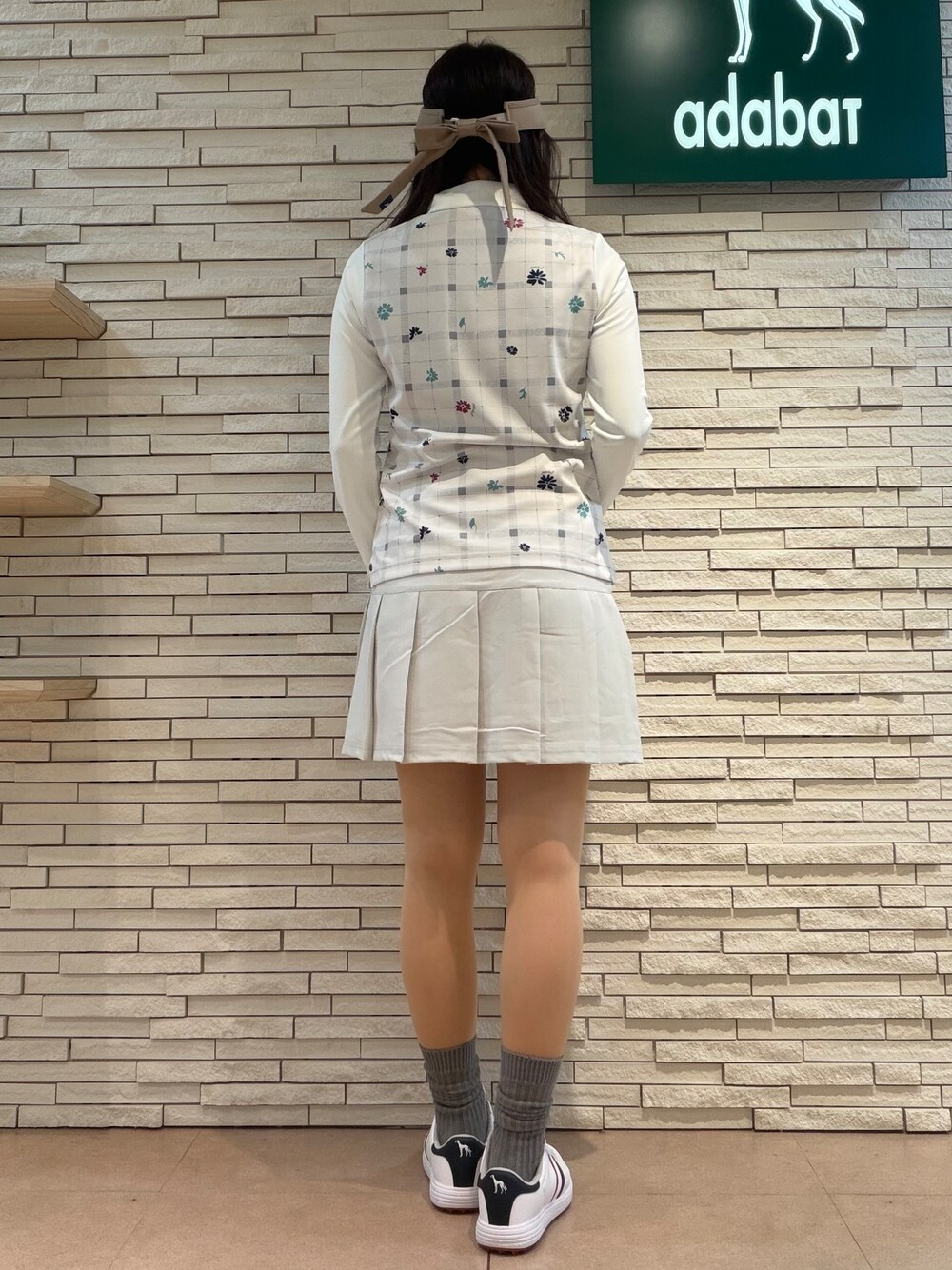 ベージュ系のTシャツ/カットソー、グレー系のスカート、ブルー系のトートバッグを着用したレディースの夏コーディネートの6枚目の写真