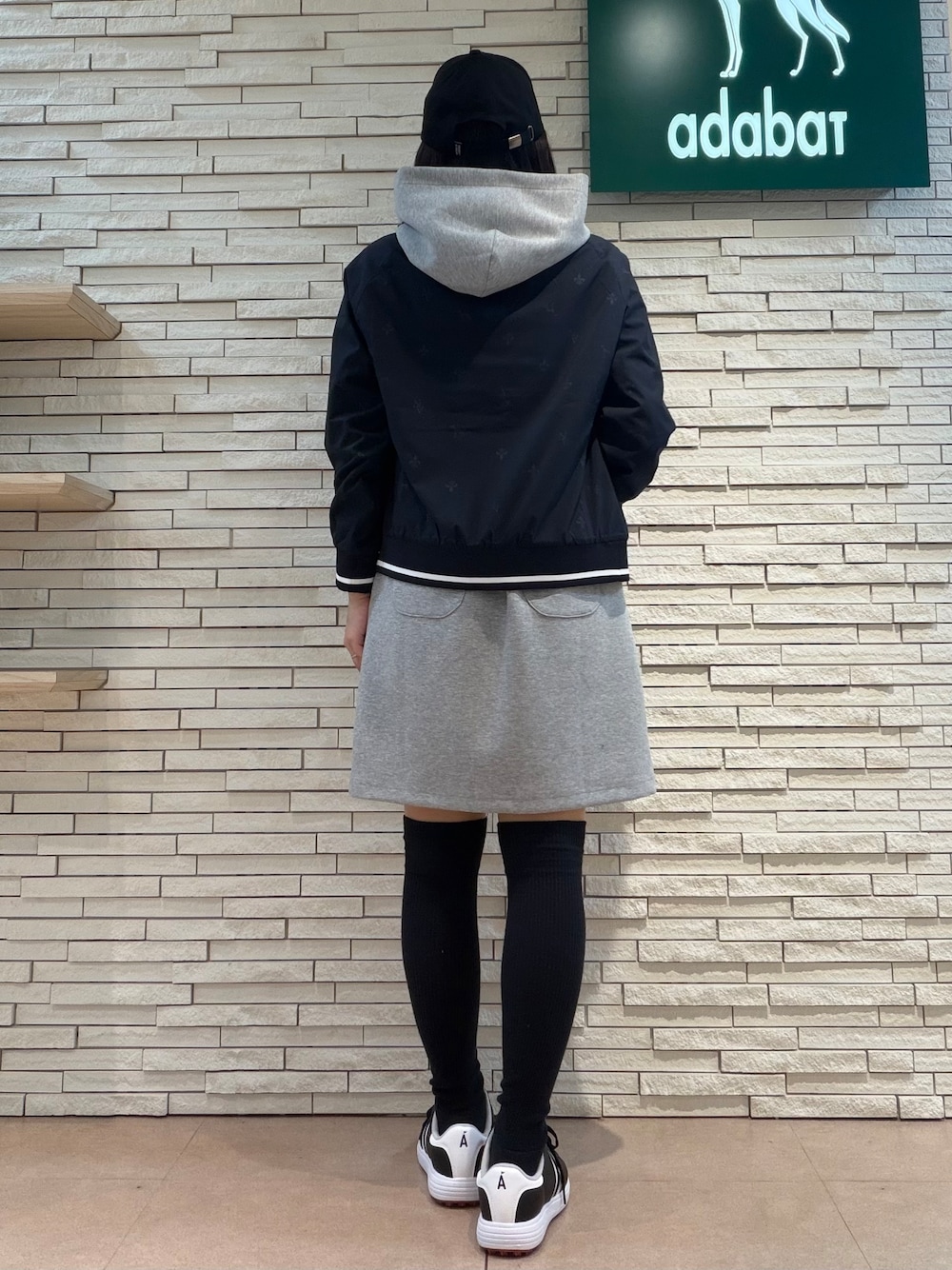 グレー系のワンピース、ブルー系のブルゾン、ブラック系のトートバッグを着用したレディースの秋コーディネートの3枚目の写真
