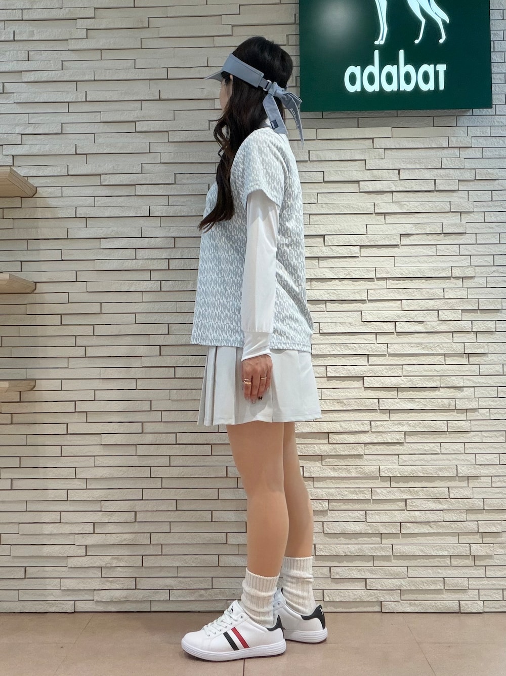 ホワイト系のTシャツ/カットソー、グレー系のポロシャツ、グレー系のスカートを着用したレディースの秋コーディネートの6枚目の写真
