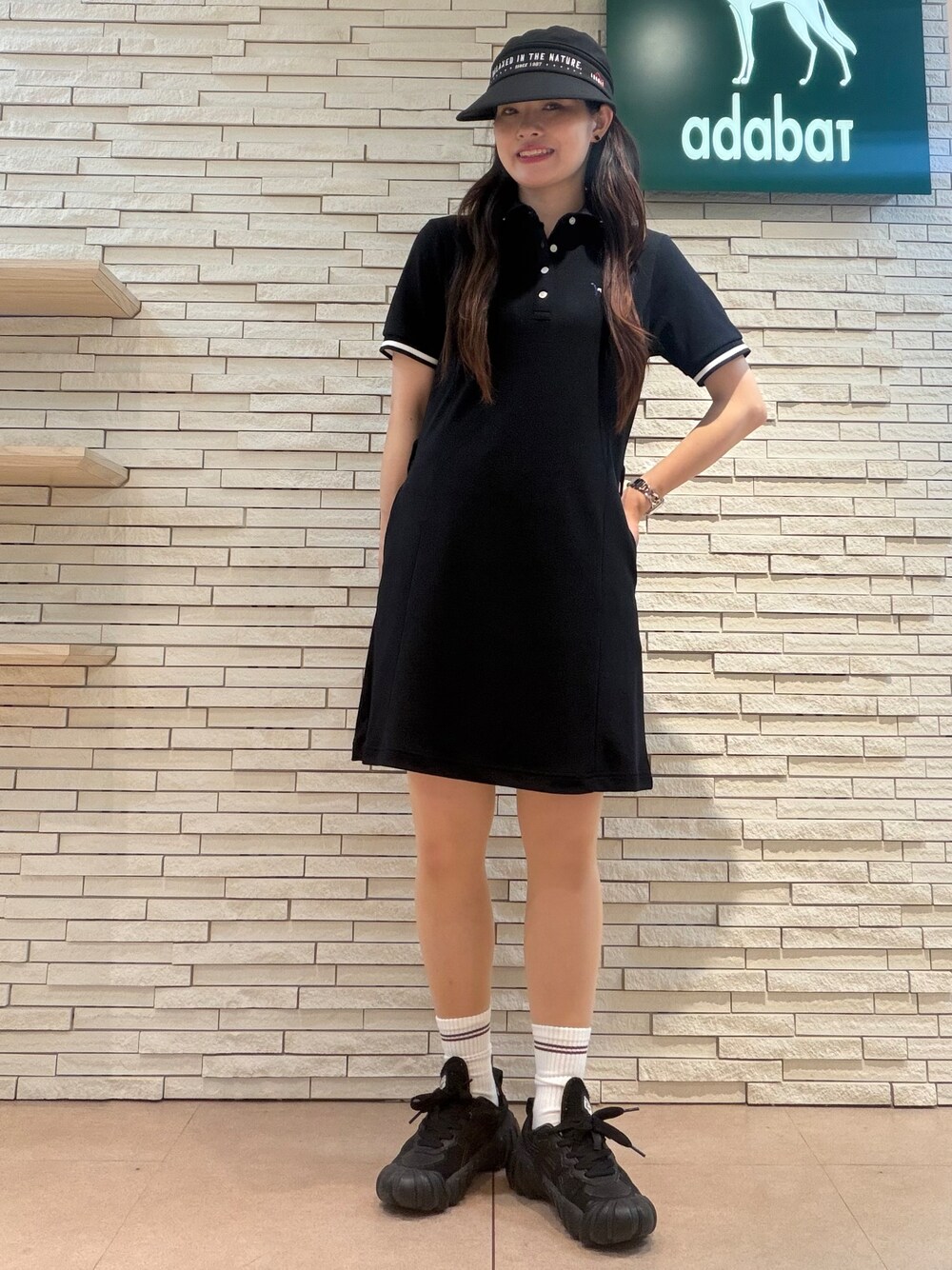 ブルー系のワンピース、ブラック系のトートバッグ、ブラック系のハットを着用したレディースの夏コーディネートの5枚目の写真