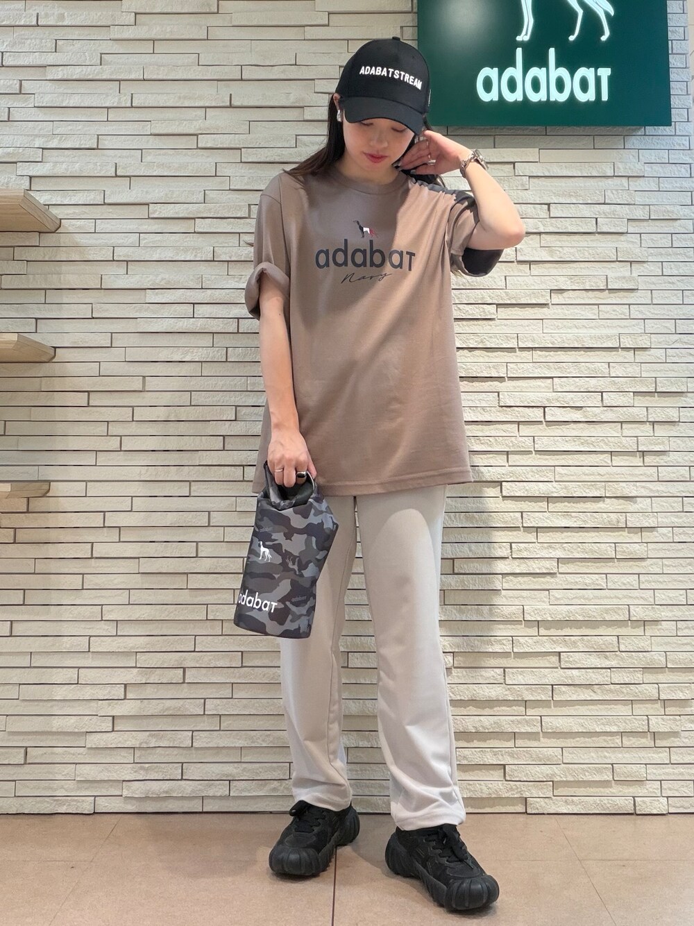 ブラウン系のTシャツ/カットソー、ベージュ系のその他パンツ、ブラック系のキャップを着用したレディースの夏コーディネートの4枚目の写真