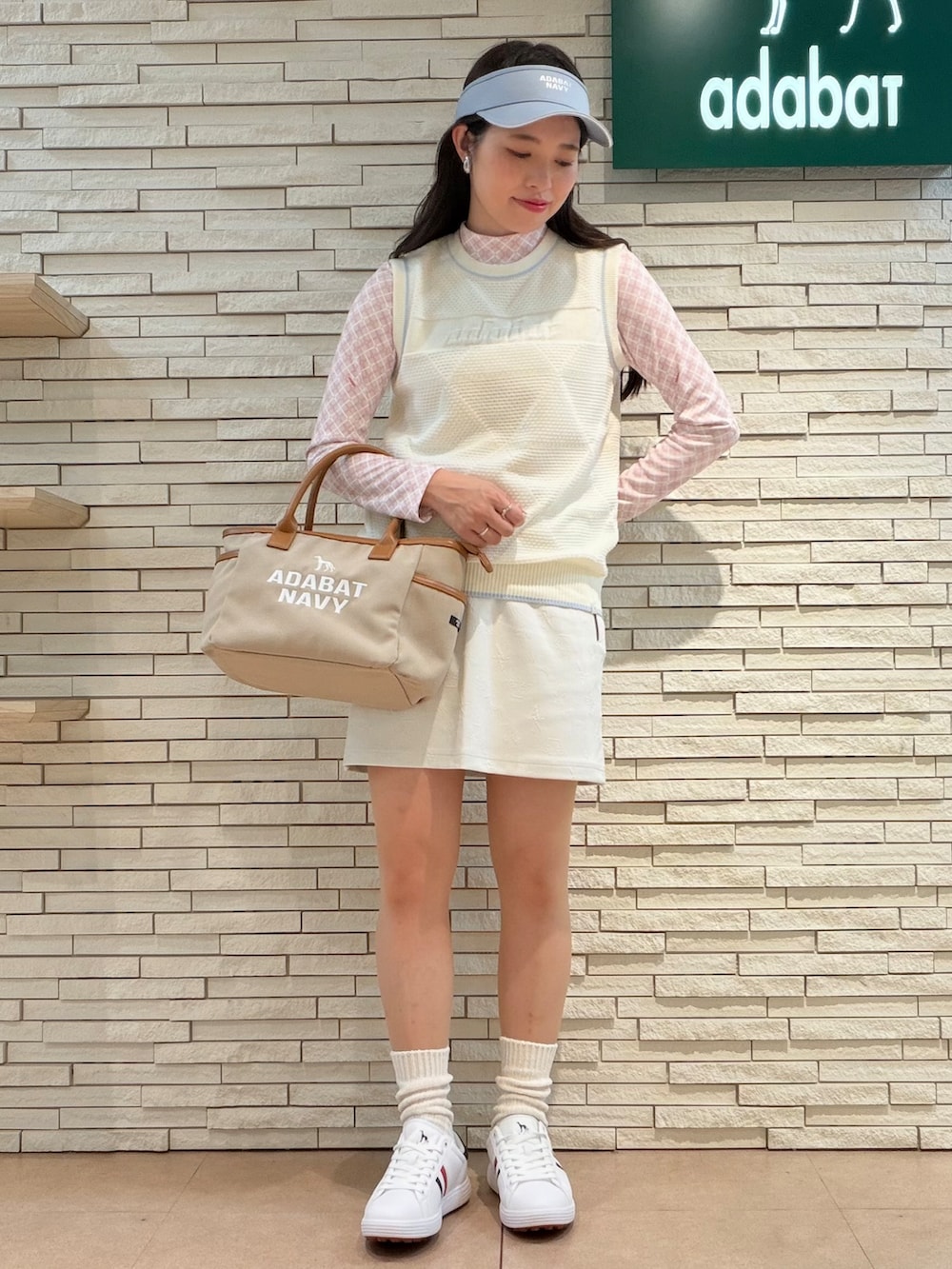 ピンク系のTシャツ/カットソー、ホワイト系のベスト、ホワイト系のスカートを着用したレディースの秋コーディネートの4枚目の写真