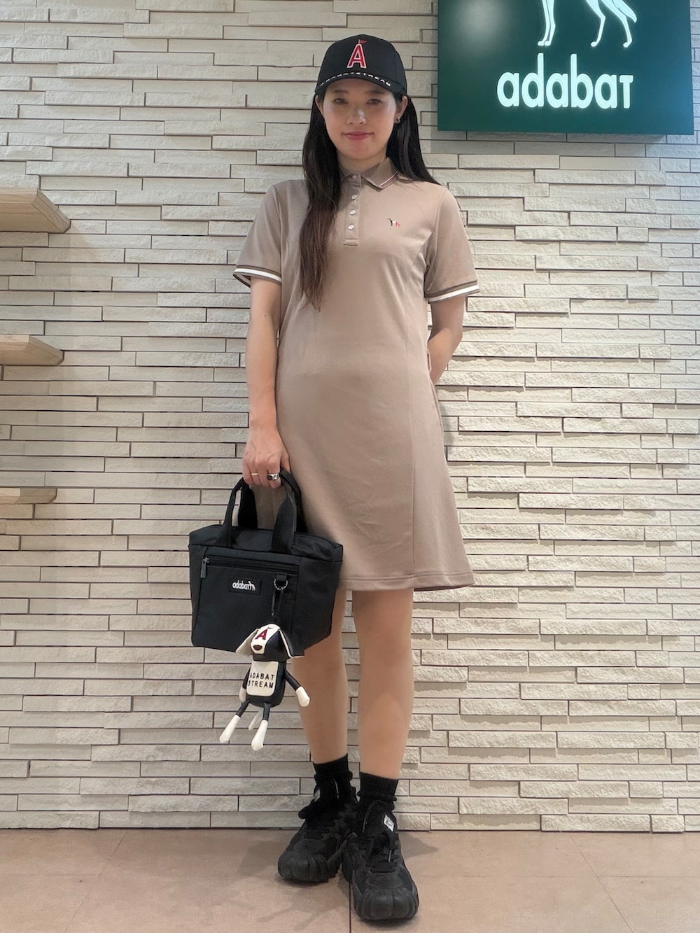 ベージュ系のワンピース、ブラック系のキャップ、ブラック系のポーチを着用したレディースの夏コーディネートの5枚目の写真
