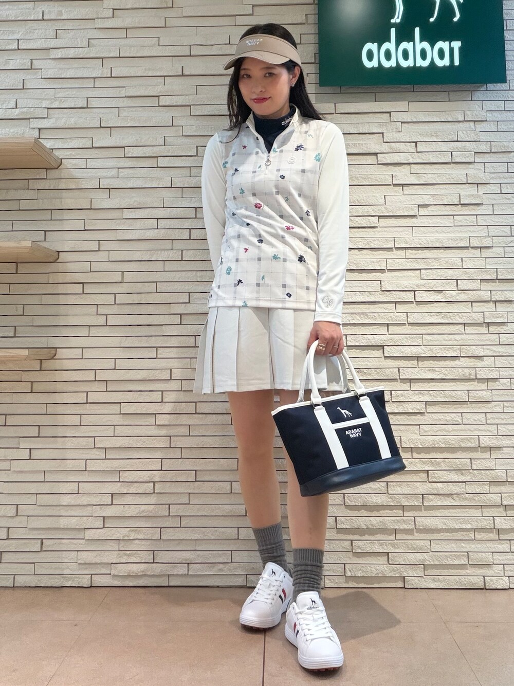ベージュ系のTシャツ/カットソー、グレー系のスカート、ブルー系のトートバッグを着用したレディースの夏コーディネートの4枚目の写真
