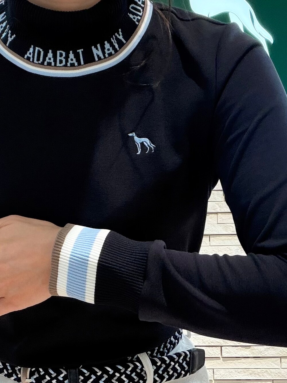 ブラック系のTシャツ/カットソー、ホワイト系のスカート、ブラック系のトートバッグを着用したレディースの秋コーディネートの6枚目の写真