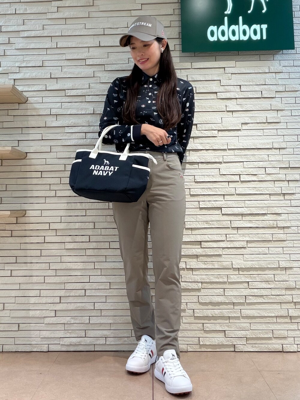 ブルー系のポロシャツ、ベージュ系のその他パンツ、ブルー系のトートバッグを着用したレディースの夏コーディネートの4枚目の写真