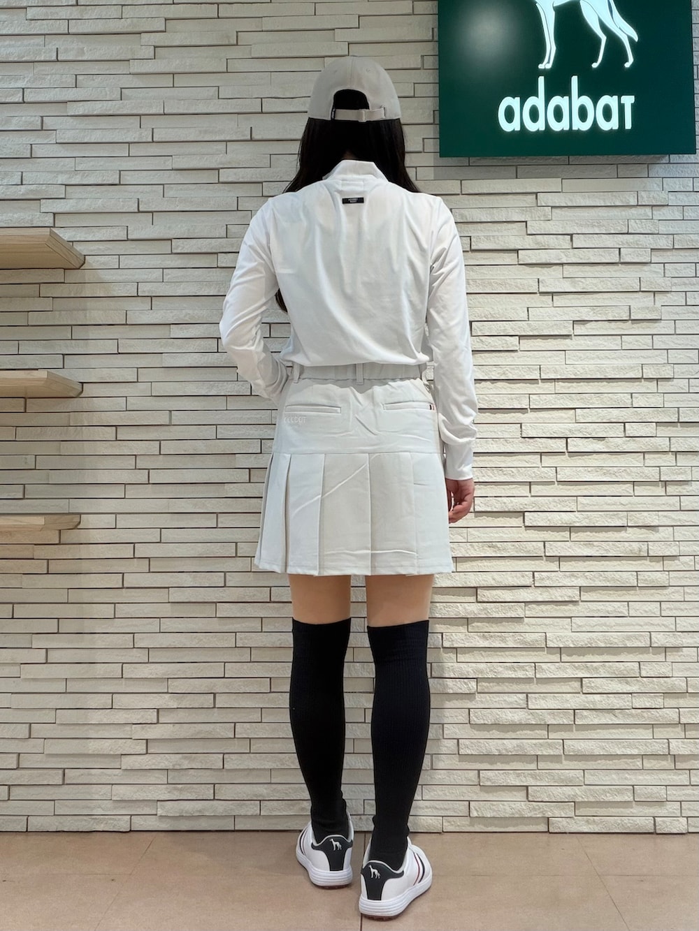 ホワイト系のTシャツ/カットソー、グレー系のスカート、ベージュ系のトートバッグを着用したレディースの秋コーディネートの3枚目の写真