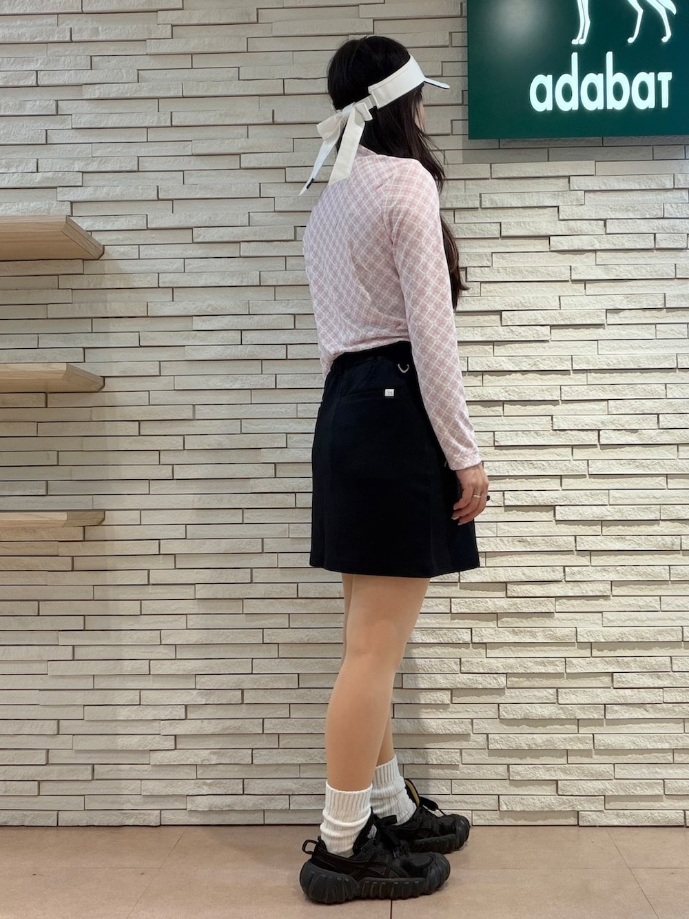 ピンク系のTシャツ/カットソー、ブラック系のスカート、ピンク系のハンドバッグを着用したレディースの秋コーディネートの2枚目の写真