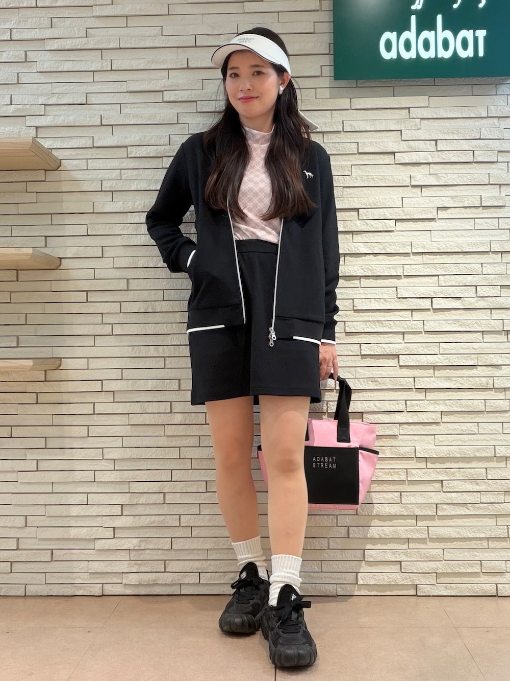 ブラック系のブルゾン、ピンク系のTシャツ/カットソー、ブラック系のスカートを着用したレディースの秋コーディネートの4枚目の写真
