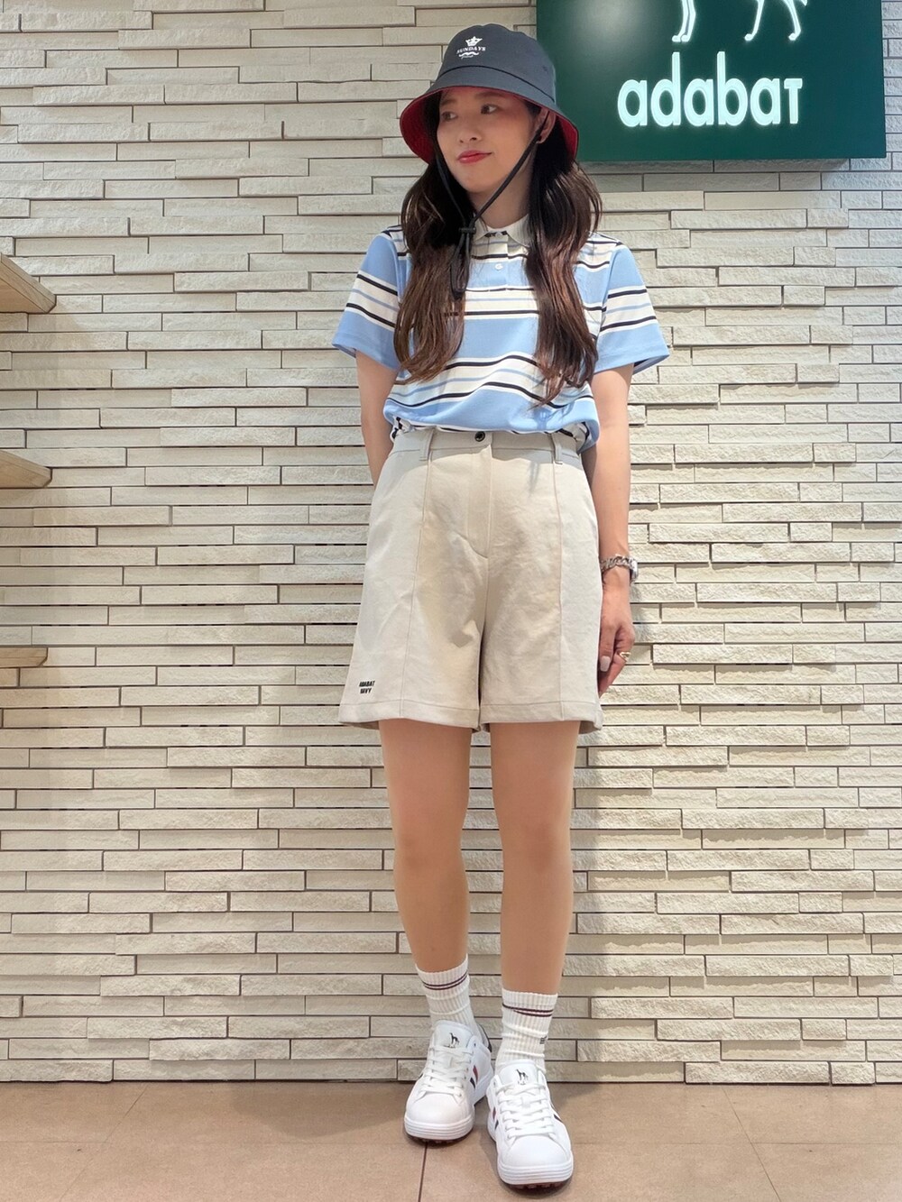 ブルー系のポロシャツ、ベージュ系のその他パンツ、ブルー系のトートバッグを着用したレディースの夏コーディネートの5枚目の写真