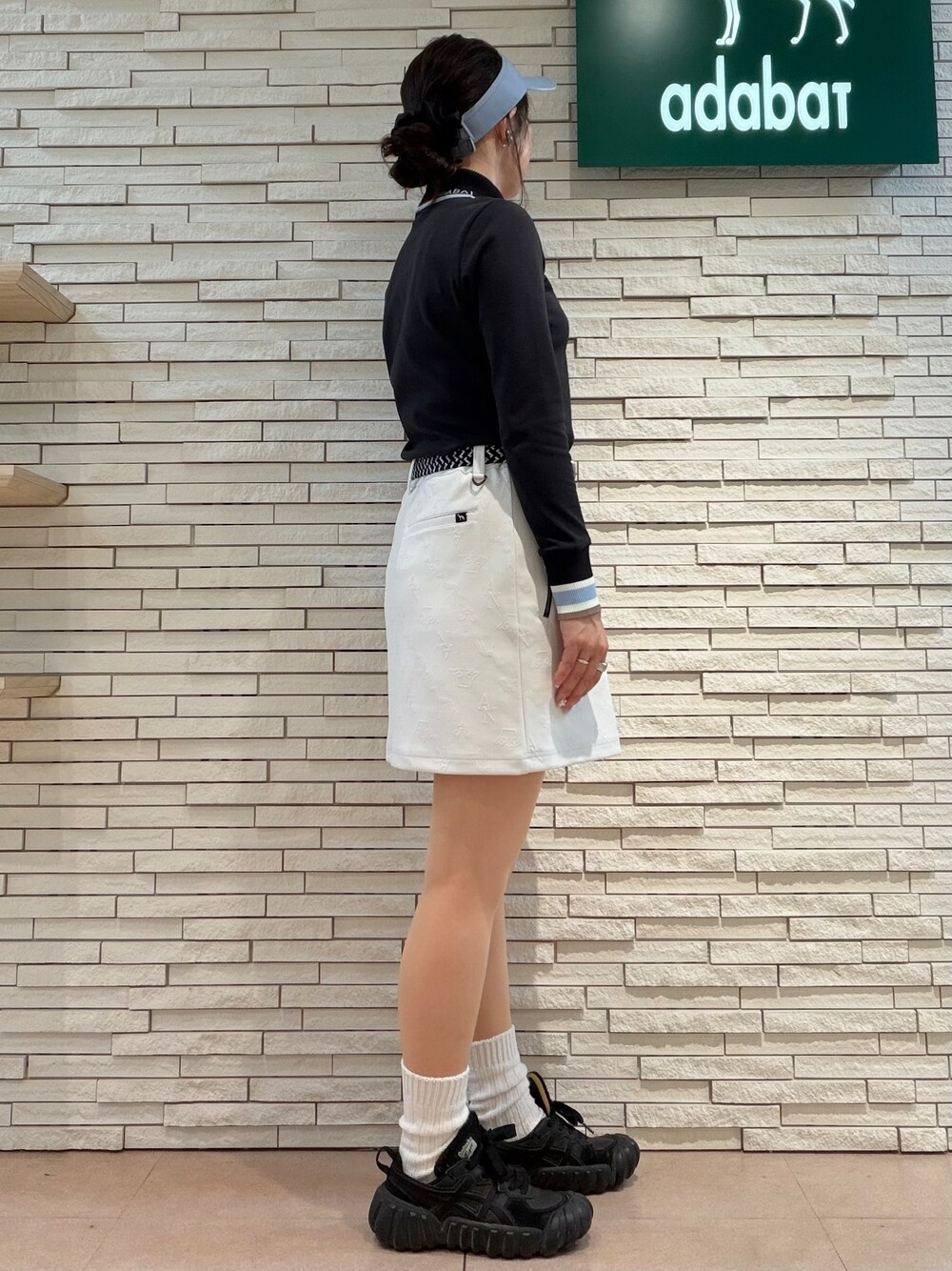ブラック系のTシャツ/カットソー、ホワイト系のスカート、ブラック系のトートバッグを着用したレディースの秋コーディネートの2枚目の写真