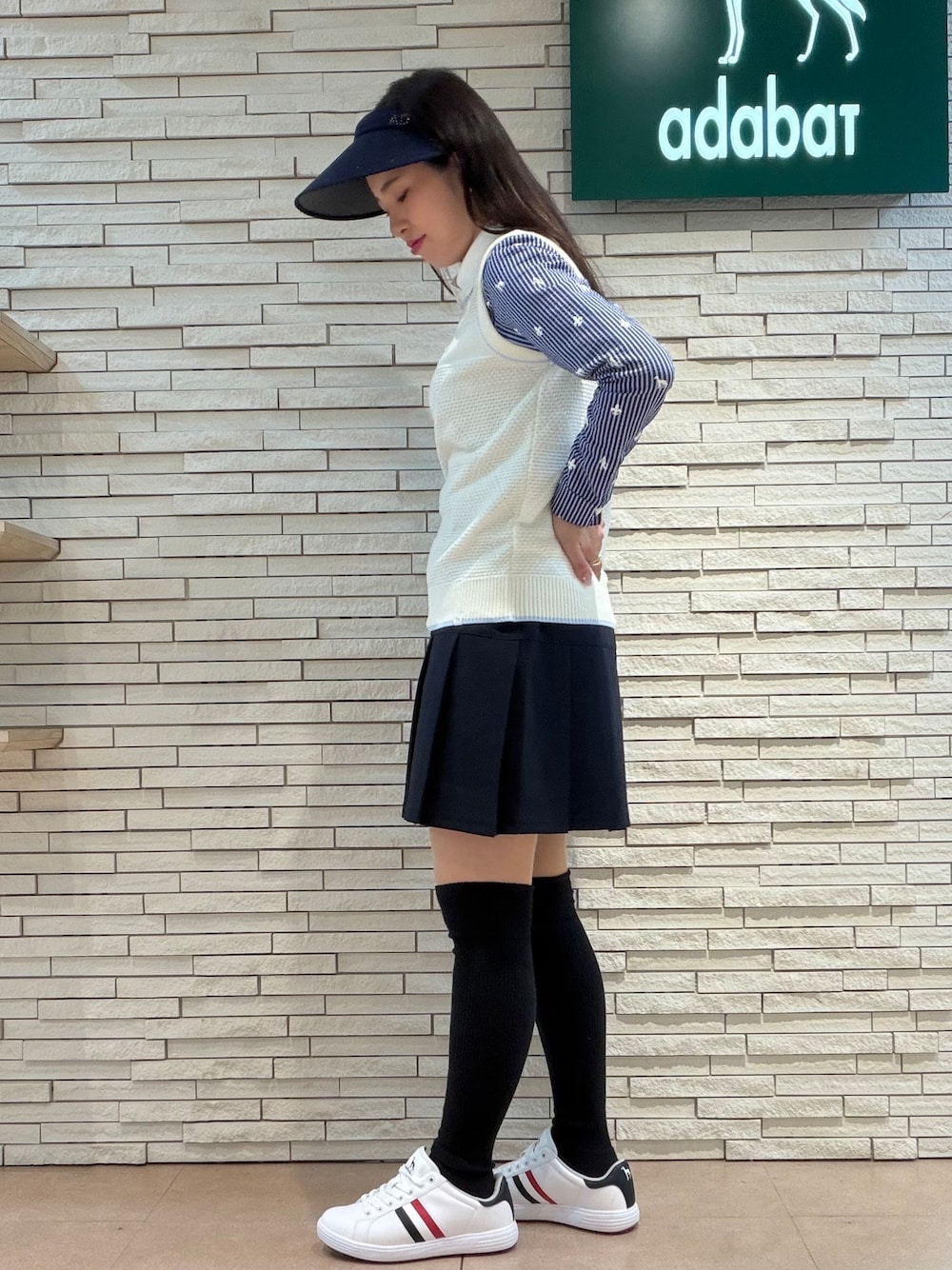 ホワイト系のベスト、ホワイト系のTシャツ/カットソー、ブルー系のスカートを着用したレディースの秋コーディネートの2枚目の写真