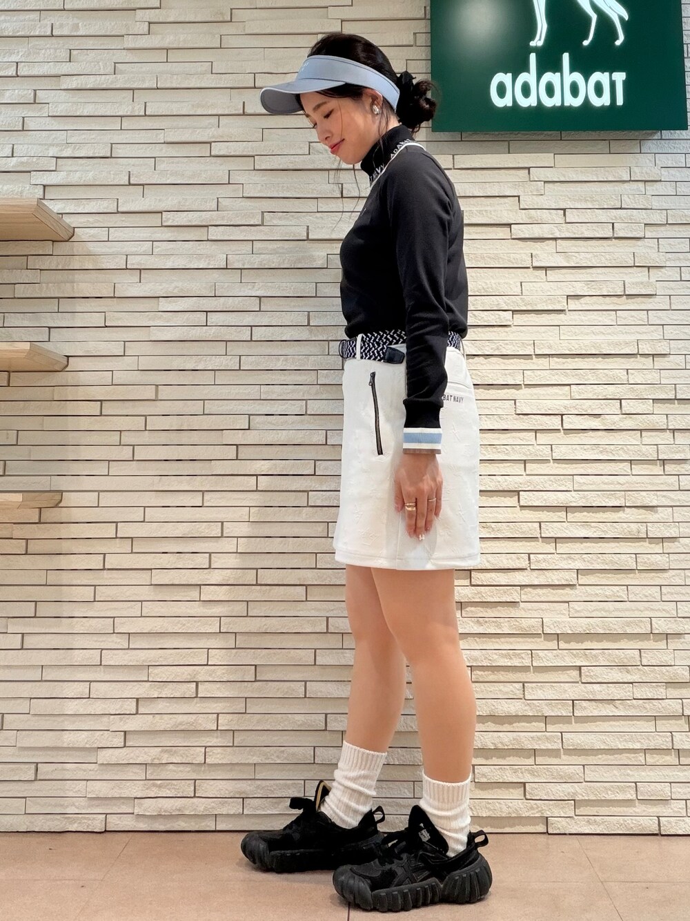 ブラック系のTシャツ/カットソー、ホワイト系のスカート、ブラック系のトートバッグを着用したレディースの秋コーディネートの4枚目の写真