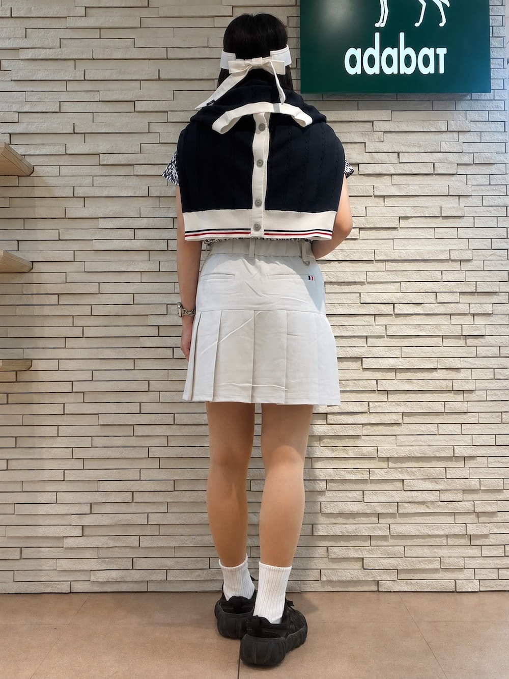 ブルー系のポロシャツ、ブルー系のカーディガン/ボレロ、グレー系のスカートを着用したレディースの夏コーディネートの3枚目の写真