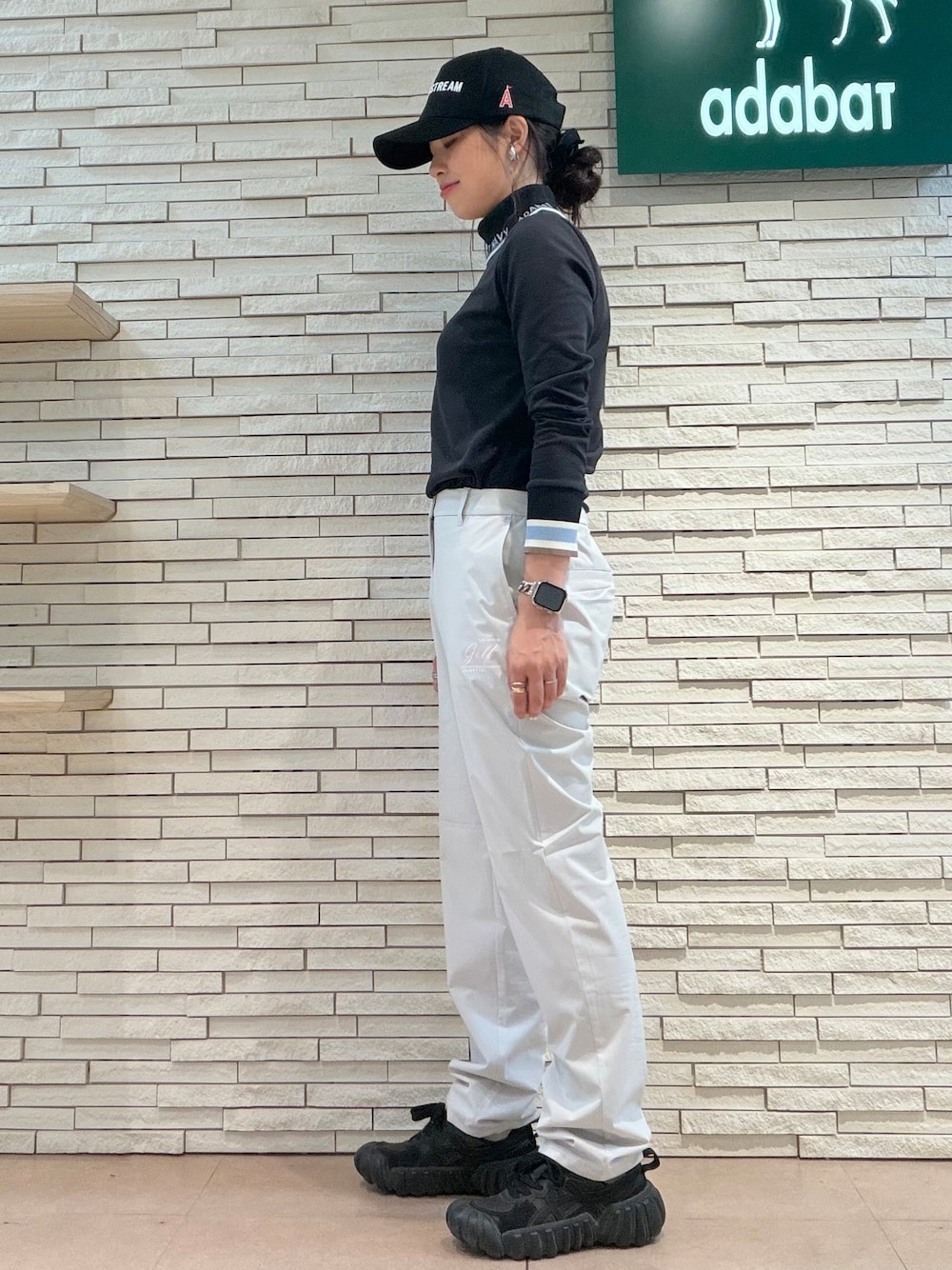 ブラック系のTシャツ/カットソー、グレー系のその他パンツ、ブラック系のキャップを着用したレディースの秋コーディネートの2枚目の写真