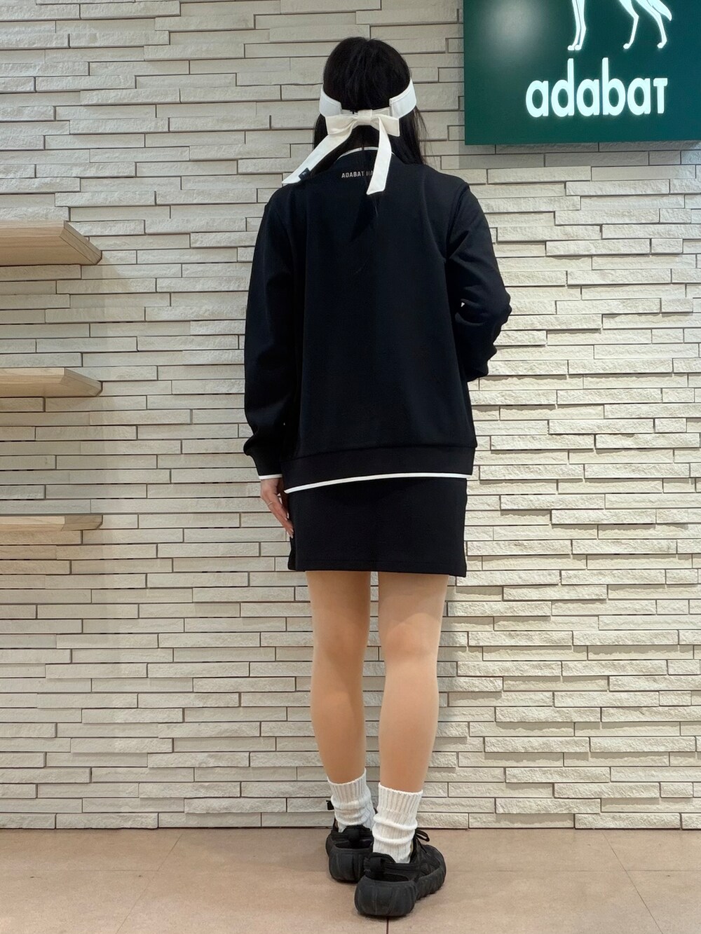 ブラック系のブルゾン、ピンク系のTシャツ/カットソー、ブラック系のスカートを着用したレディースの秋コーディネートの3枚目の写真