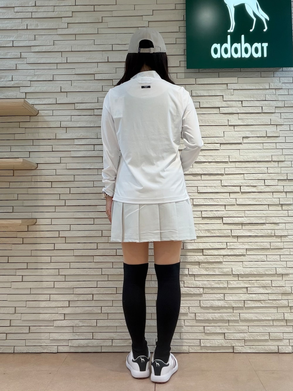 ホワイト系のTシャツ/カットソー、グレー系のスカート、ベージュ系のトートバッグを着用したレディースの秋コーディネートの8枚目の写真