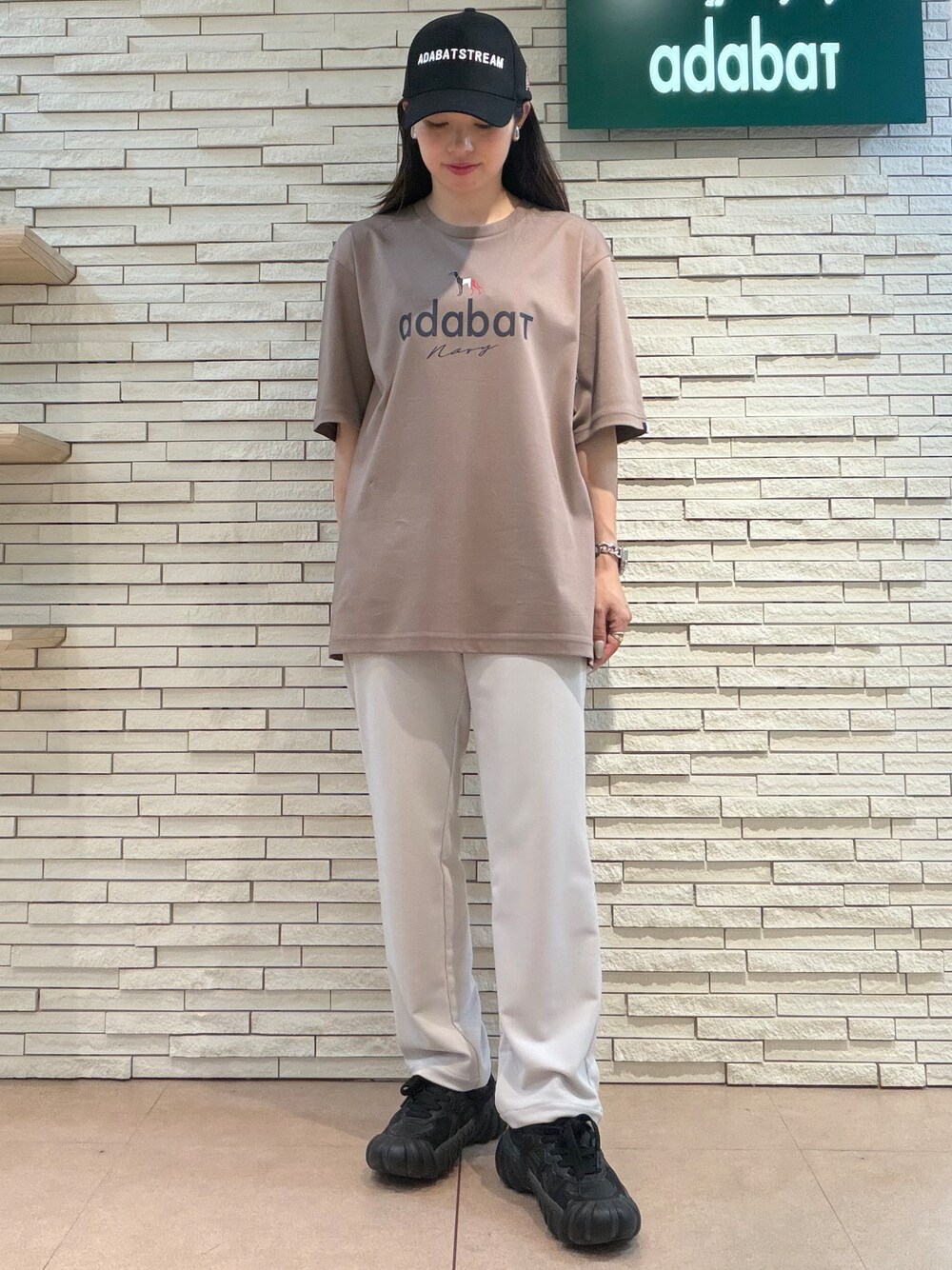 ブラウン系のTシャツ/カットソー、ベージュ系のその他パンツ、ブラック系のキャップを着用したレディースの夏コーディネートの5枚目の写真