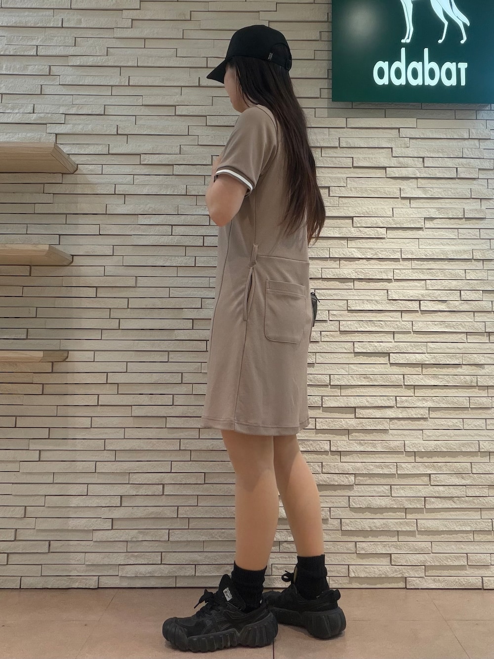 ベージュ系のワンピース、ブラック系のキャップ、ブラック系のポーチを着用したレディースの夏コーディネートの4枚目の写真